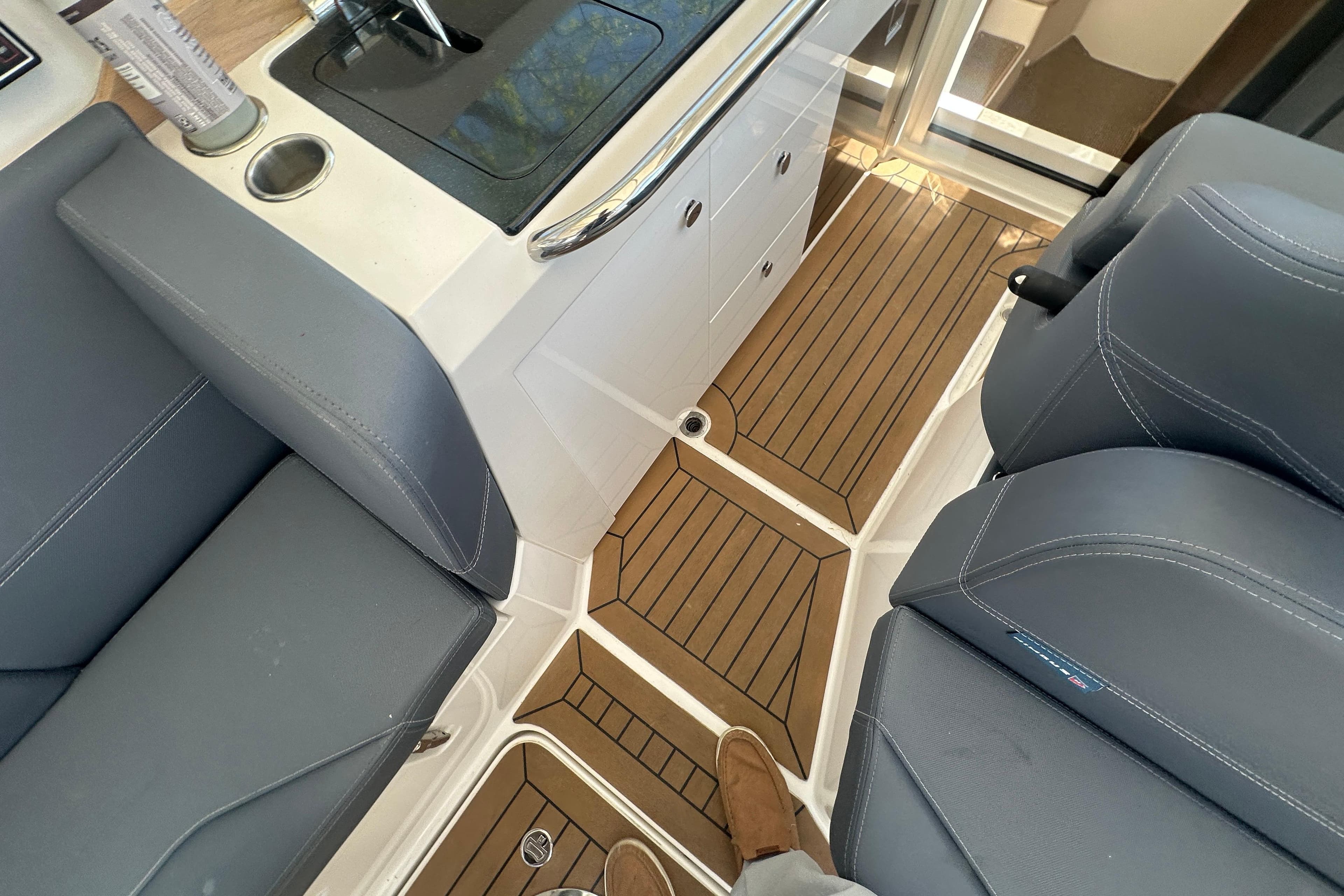 Interior of 2023 Nimbus Weekender 9 boat with sleek seating and wood-patterned flooring.