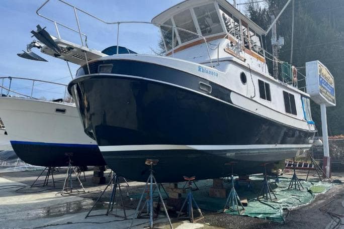 1987 Kadey-Krogen Manatee 36 boat on stands, undergoing maintenance at a marina.