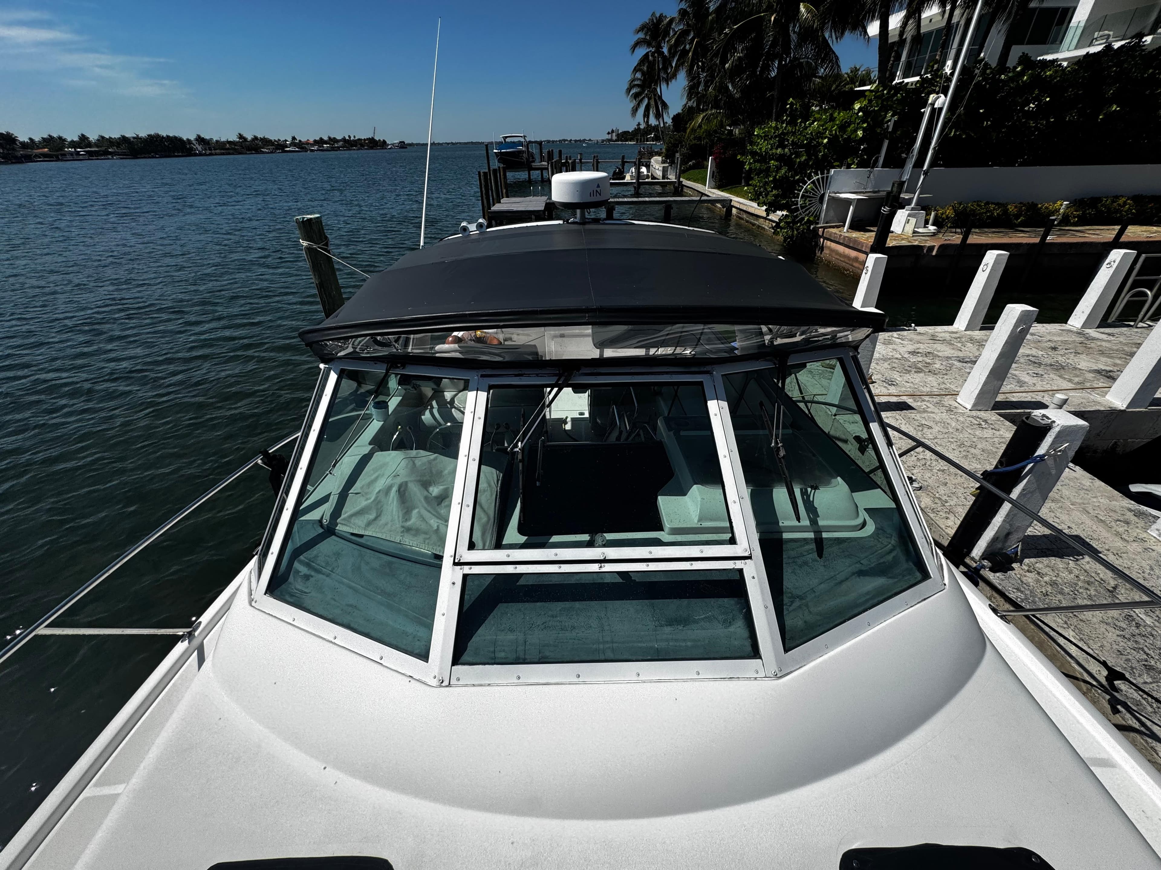 2000 Tiara Yachts 3500 Open docked by a scenic waterfront with palm trees.