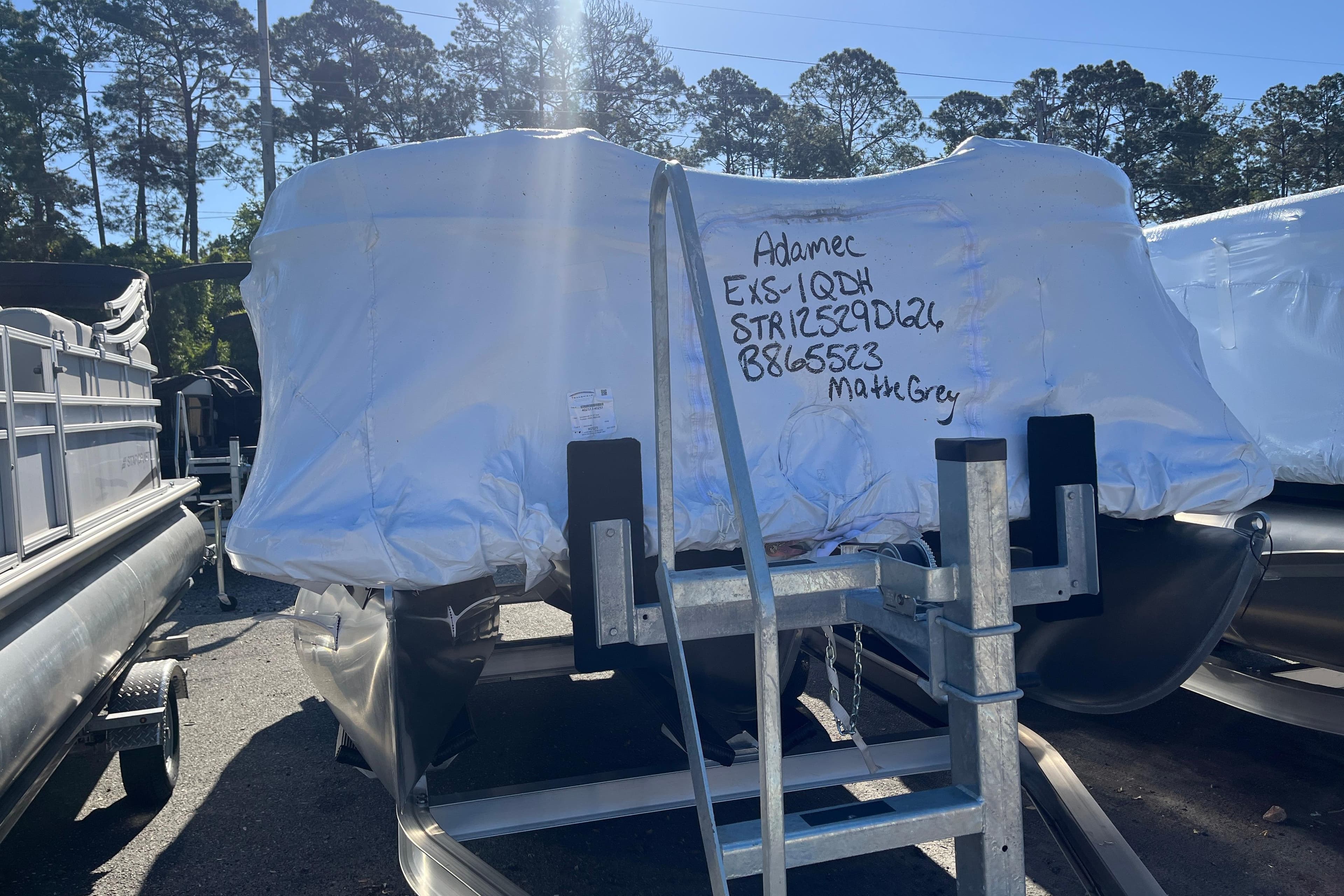 Covered 2026 Starcraft EXS 1 Q DH boat on trailer, matte grey, in outdoor setting.