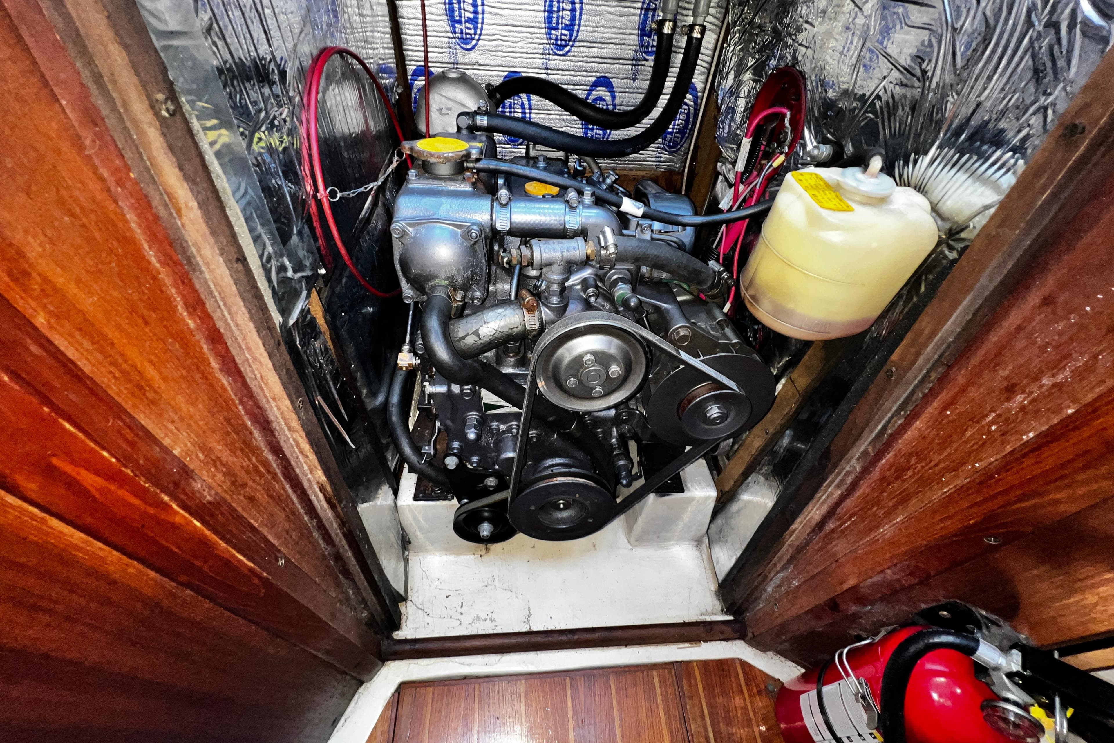 Engine compartment of 1989 Hunter Vision 32 sailboat with visible components and fire extinguisher.