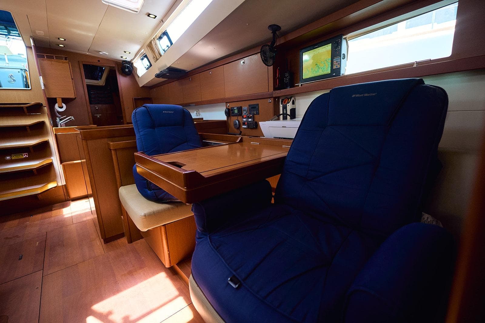 Interior of 2014 Beneteau Oceanis 48 yacht with blue seating and navigation equipment.
