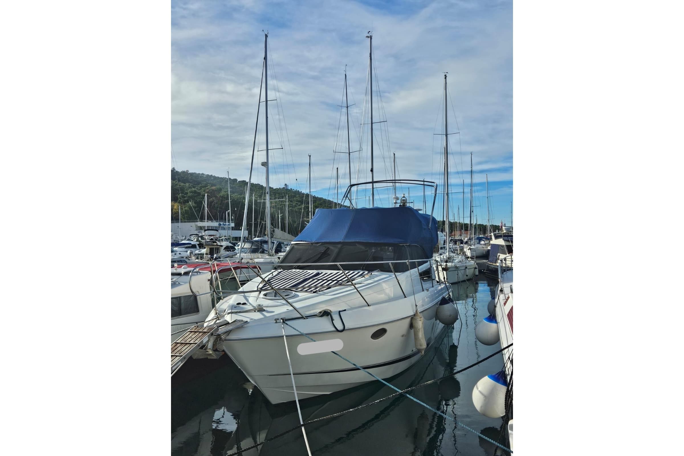 2002 Fairline Phantom 38 yacht docked in a marina, surrounded by other boats.