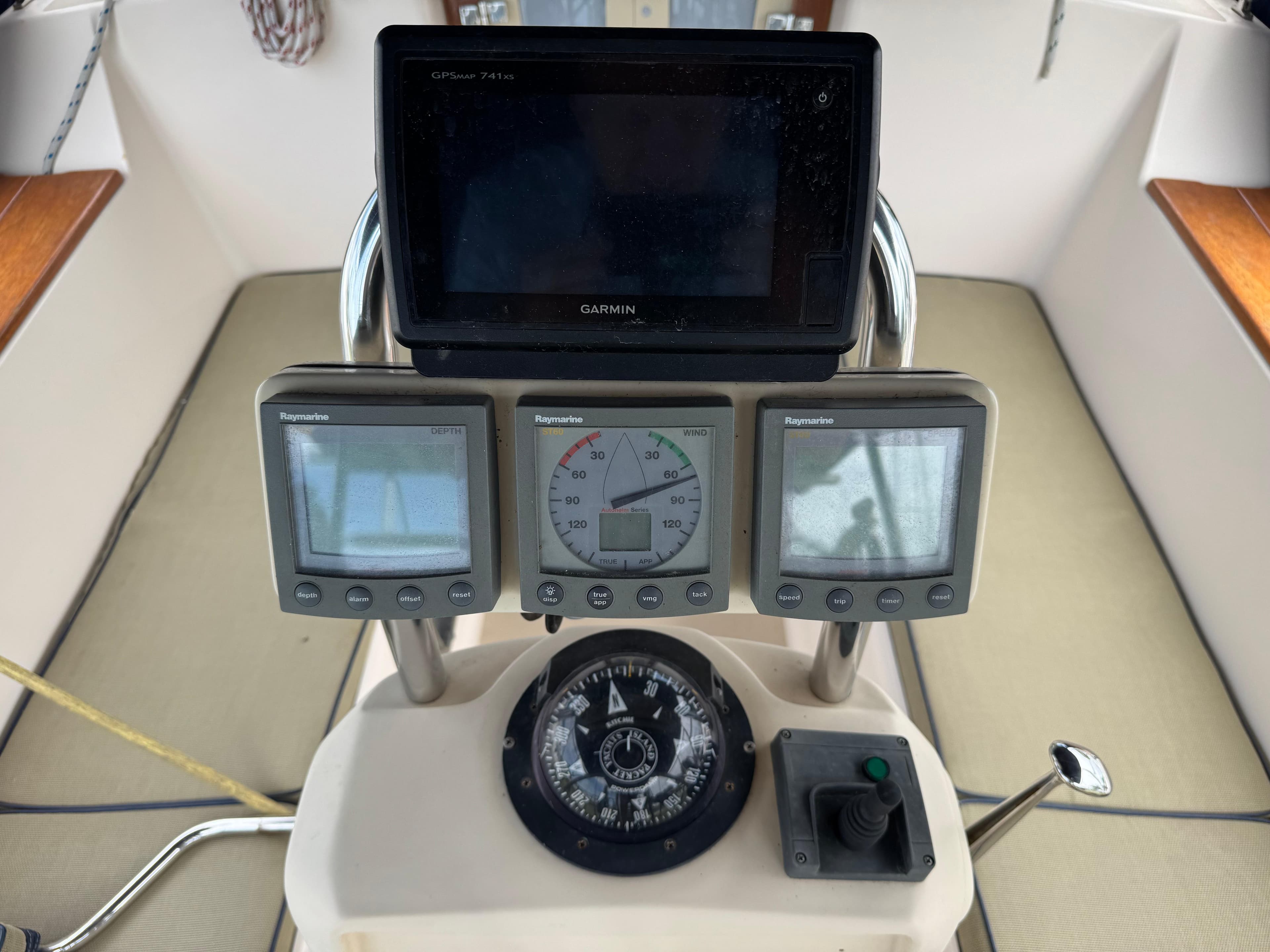 Cockpit instruments of a 2002 Island Packet 380 sailboat, featuring Raymarine displays and a compass.