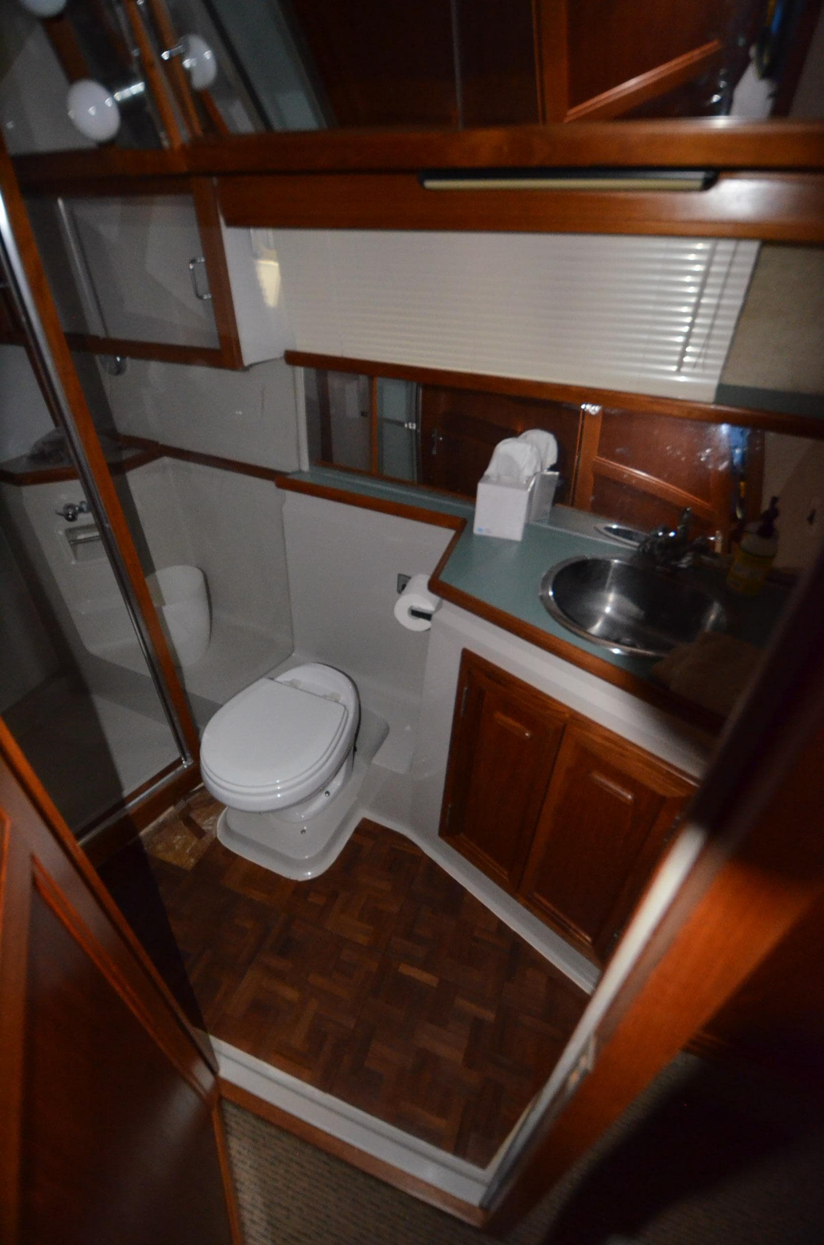 1987 Carver 4207 yacht bathroom with wood accents, sink, and toilet.