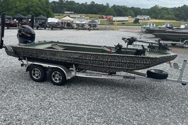 2026 Custom 1860 Ultimate Panfish boat on trailer, parked on gravel lot.