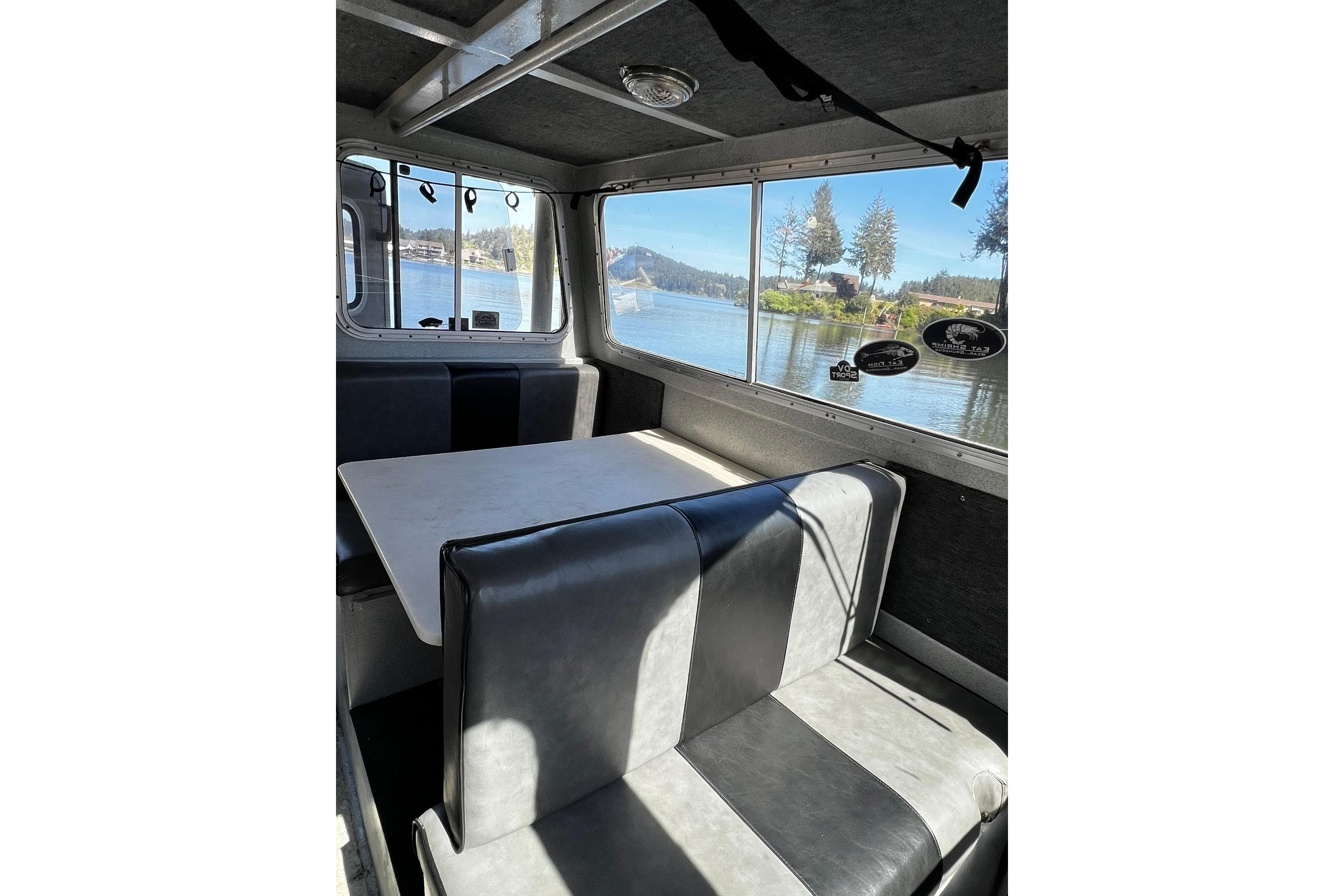 Interior of 1998 Maxweld Cuddy Hardtop boat with lake view through windows.