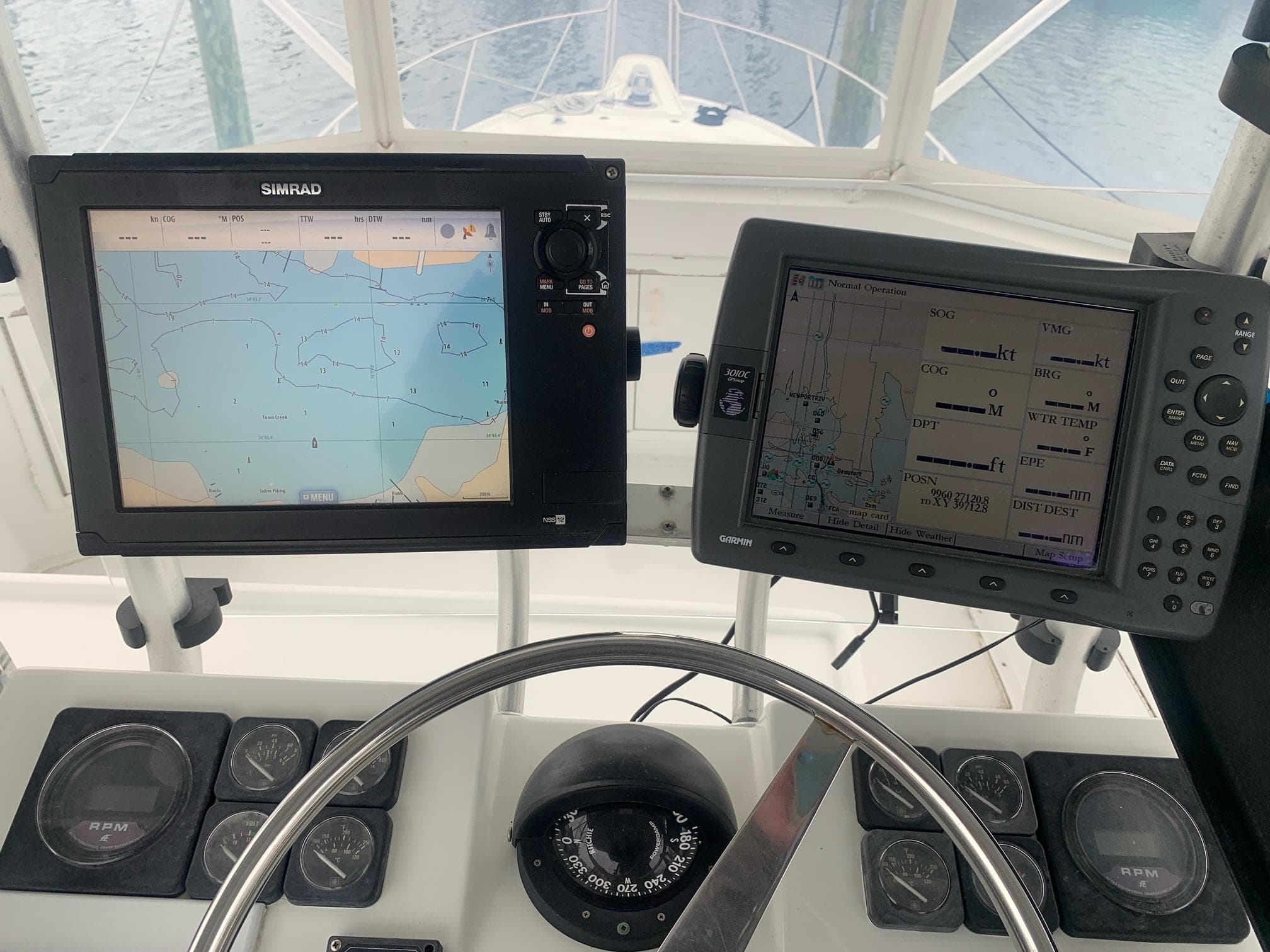Helm of 1974 Hatteras 46 Convertible with navigation screens and compass.