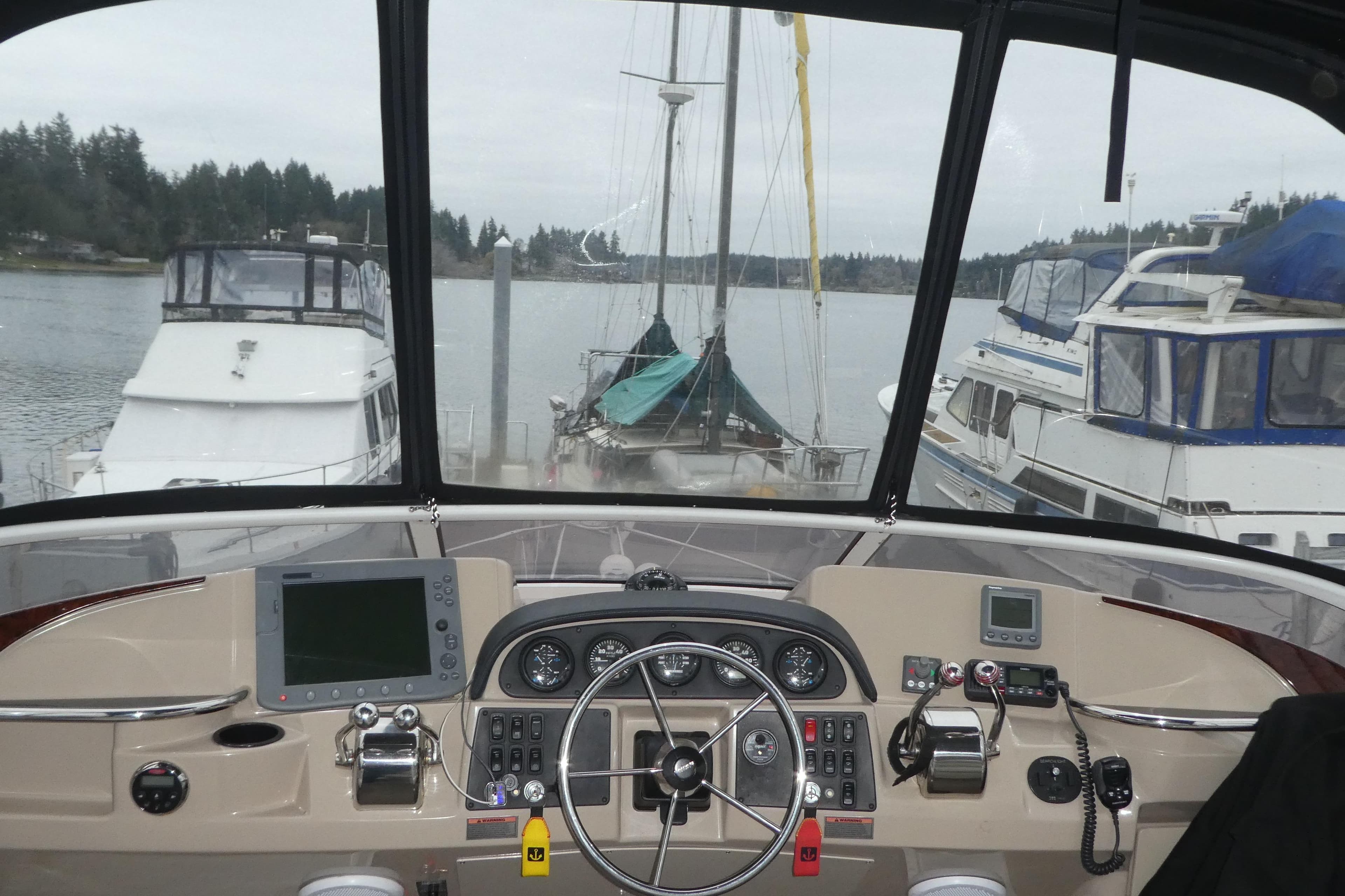 Helm of 2006 Carver 366 Motor Yacht with navigational equipment, docked in a marina.