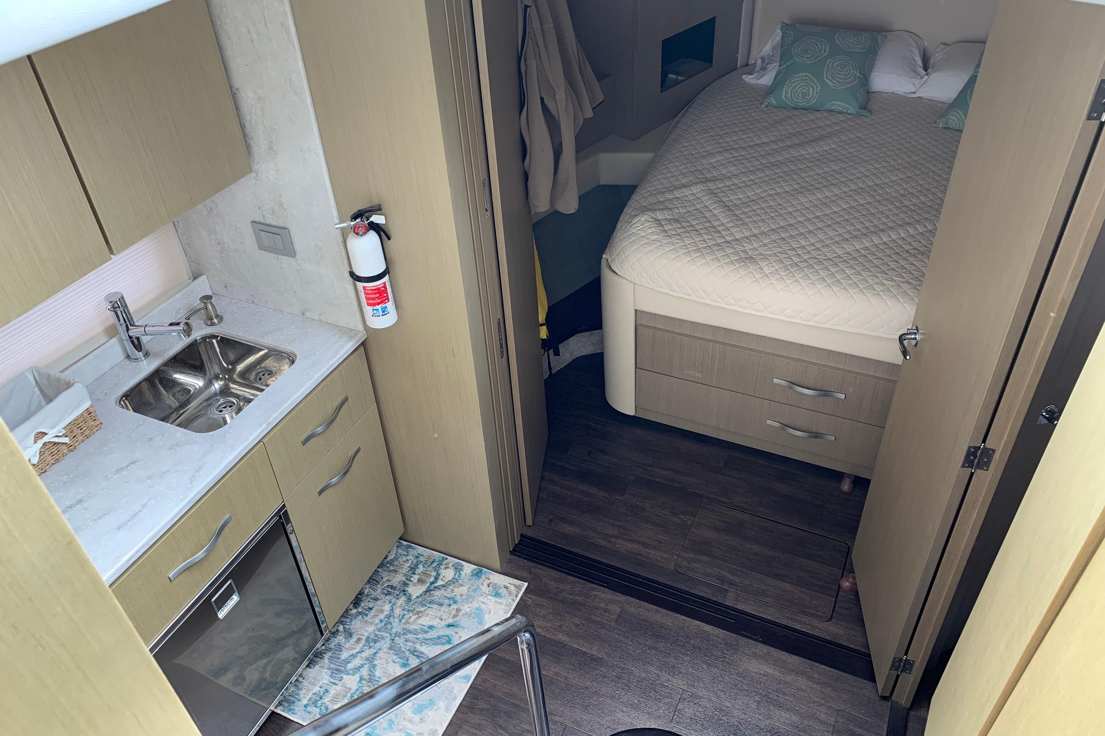 Interior of 2019 Regal 42 Grande Coupe with kitchenette and cozy bedroom.