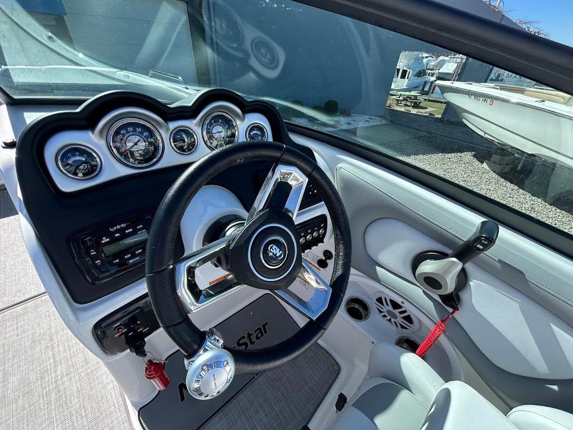 2022 NauticStar 243DC Sport Deck boat dashboard with steering wheel and gauges.