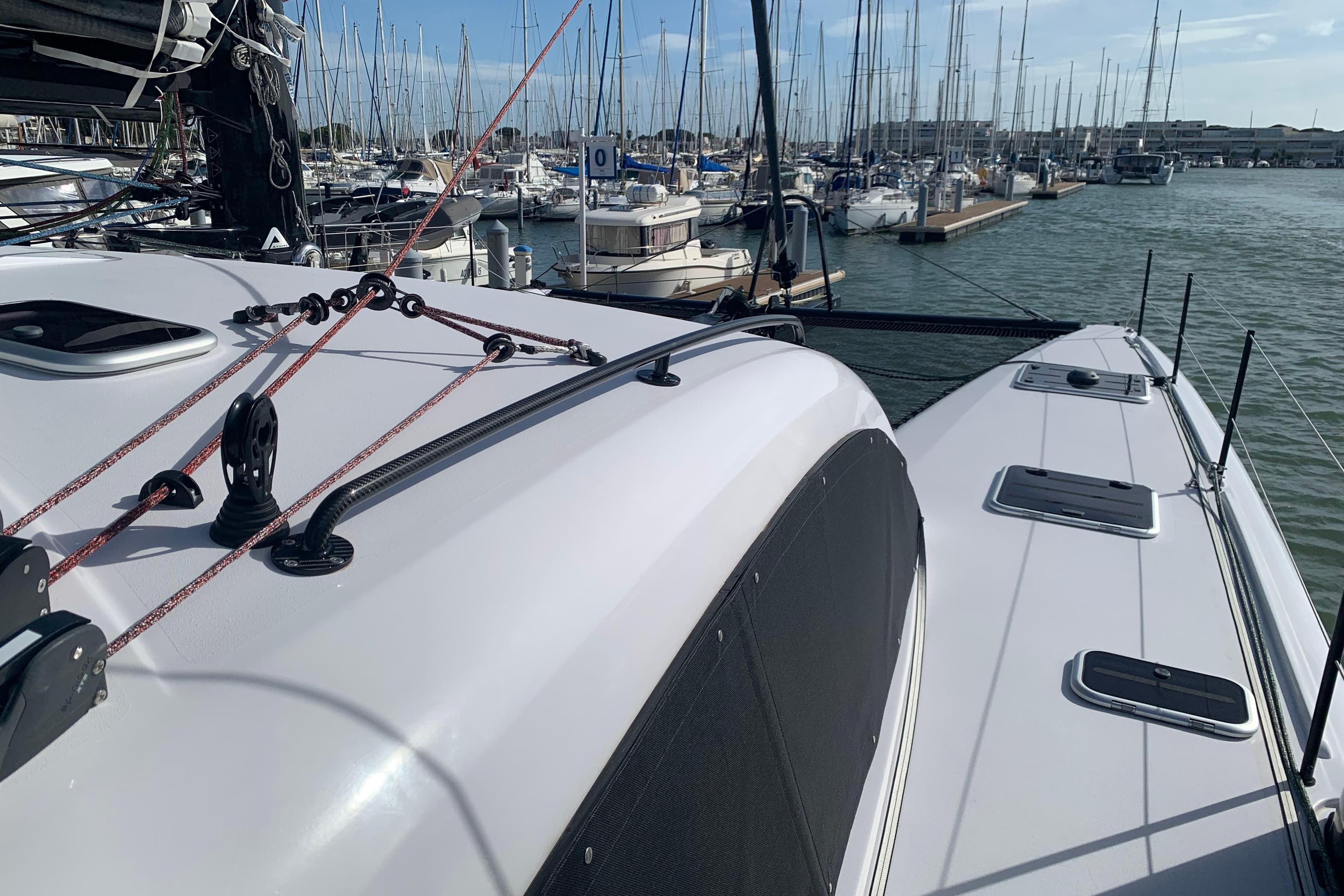 2025 Outremer 4X catamaran docked in a marina, showcasing sleek design and rigging.