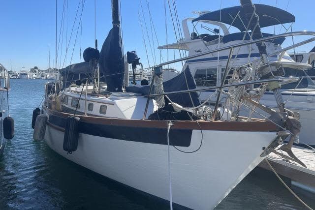 1982 Formosa 42 sailboat docked in a marina, surrounded by other boats.