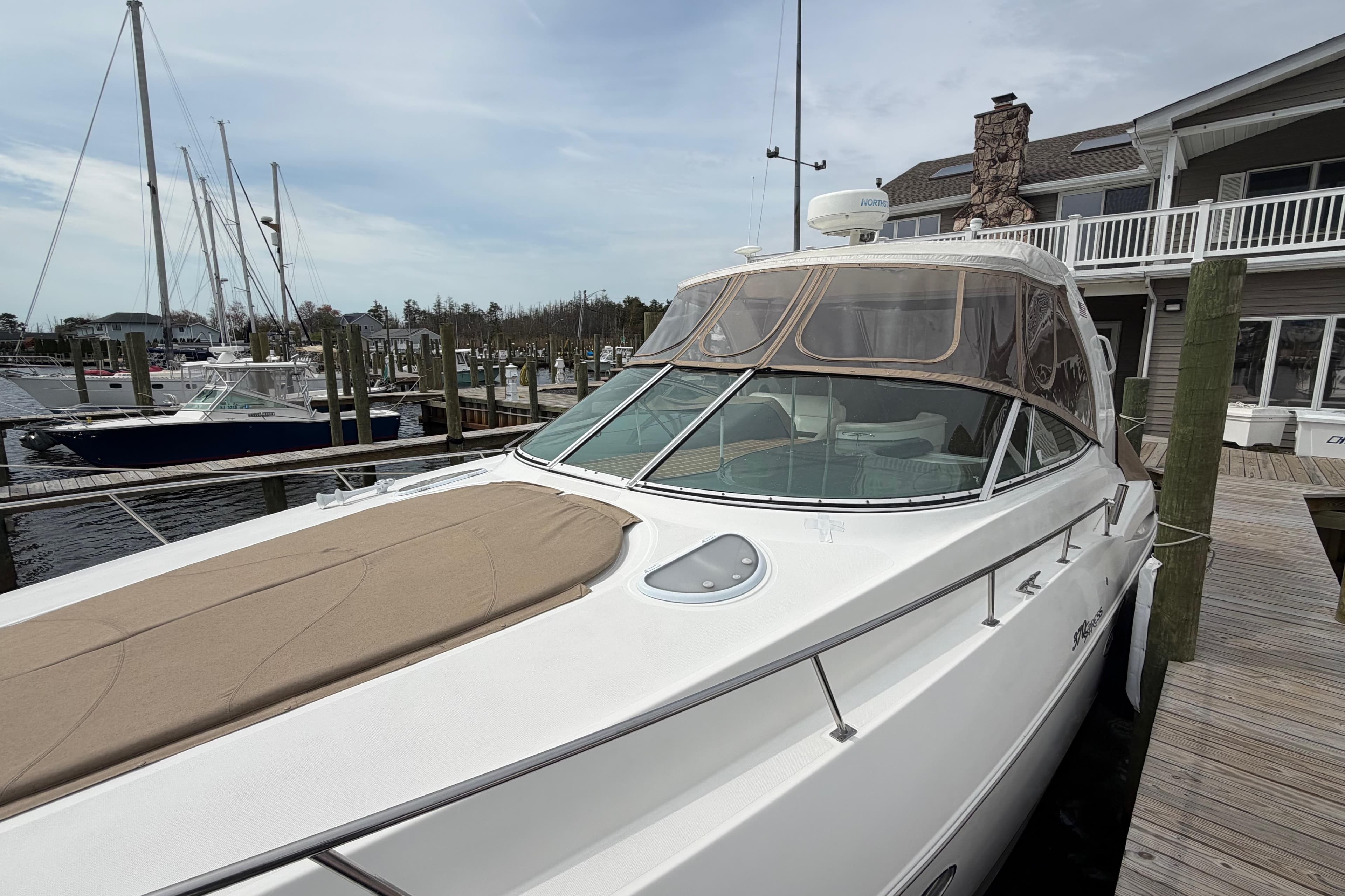 2007 Cruisers Yachts 370 Express docked at marina, showcasing sleek design and spacious deck.