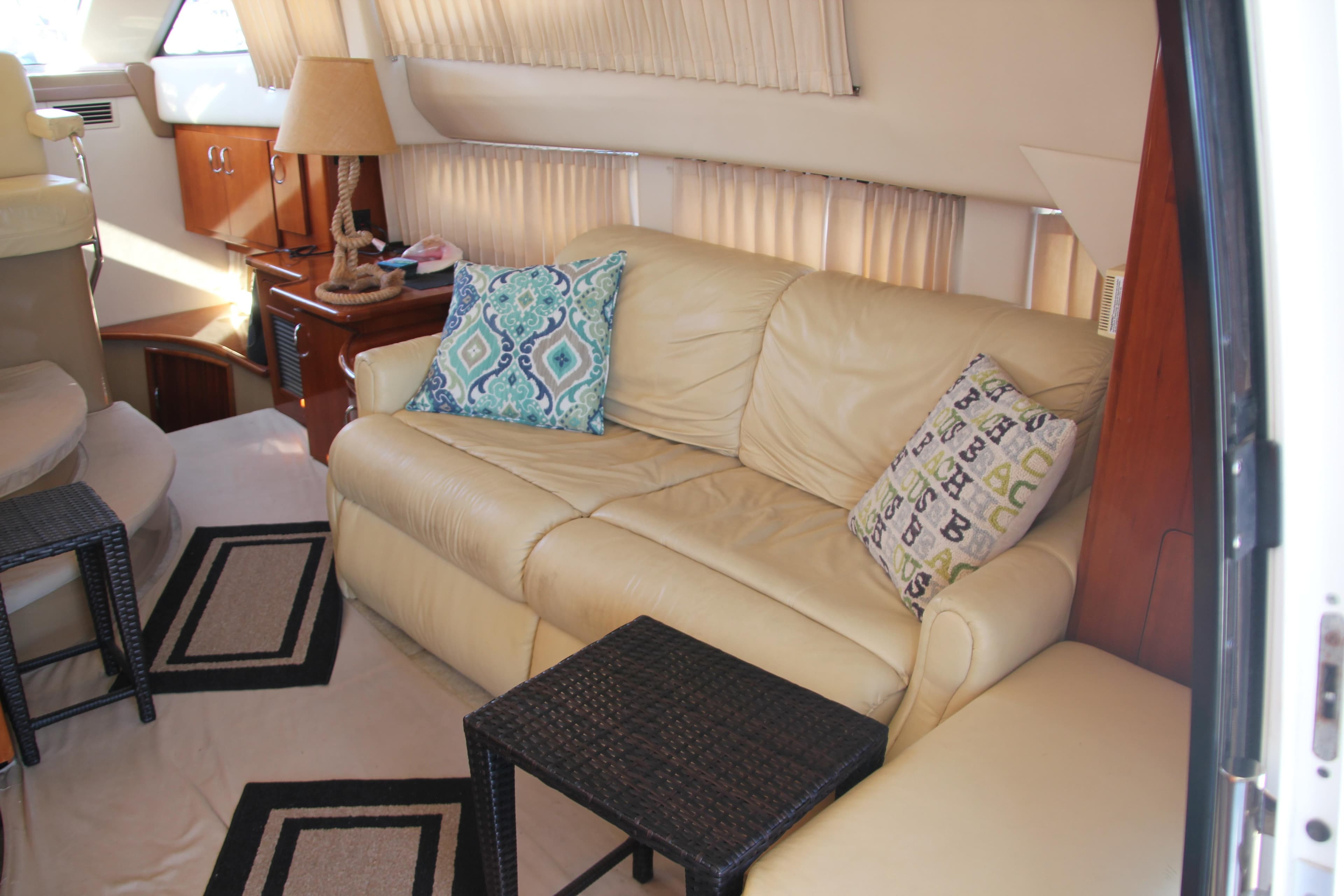 2004 Carver 360 Sport Sedan interior with beige leather sofa and decorative pillows.
