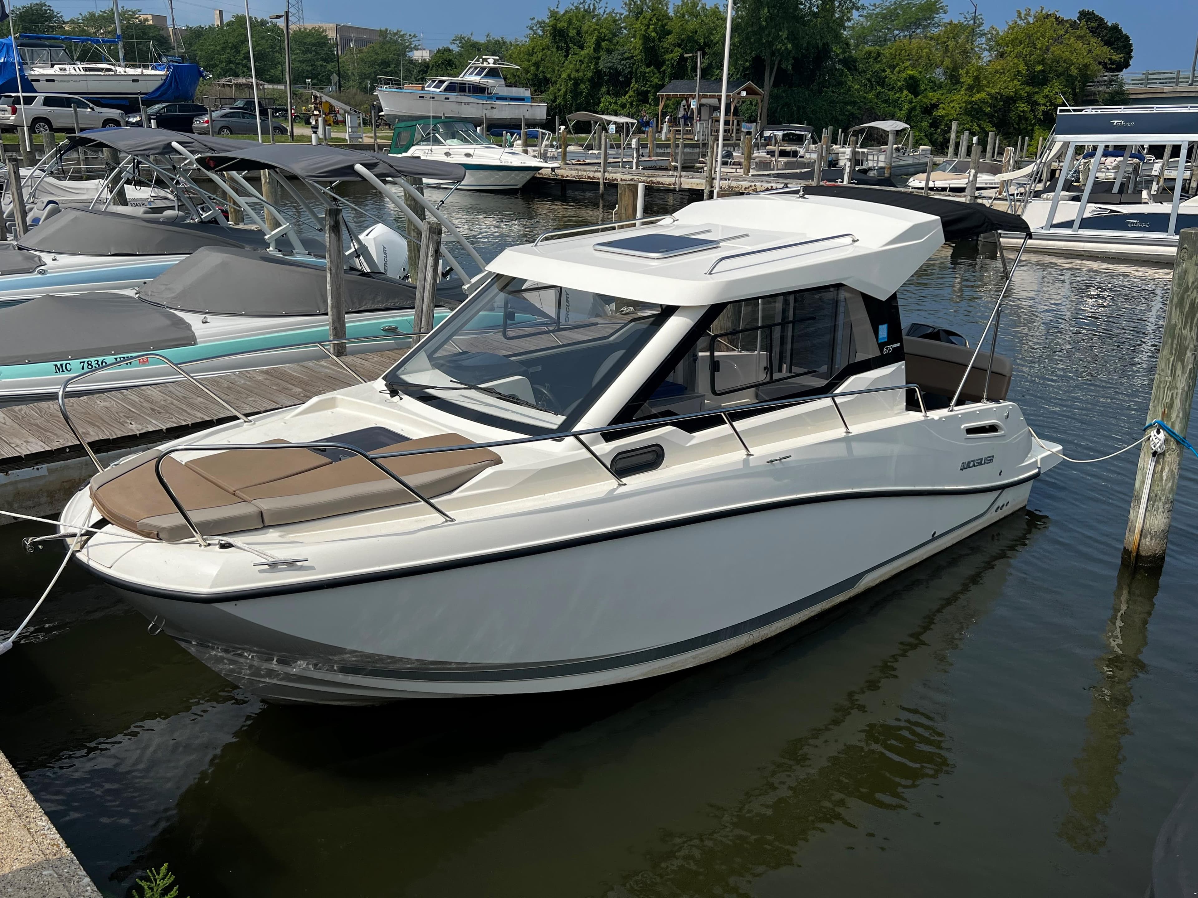 2023 Quicksilver 675 Weekend Cruiser docked at a marina.