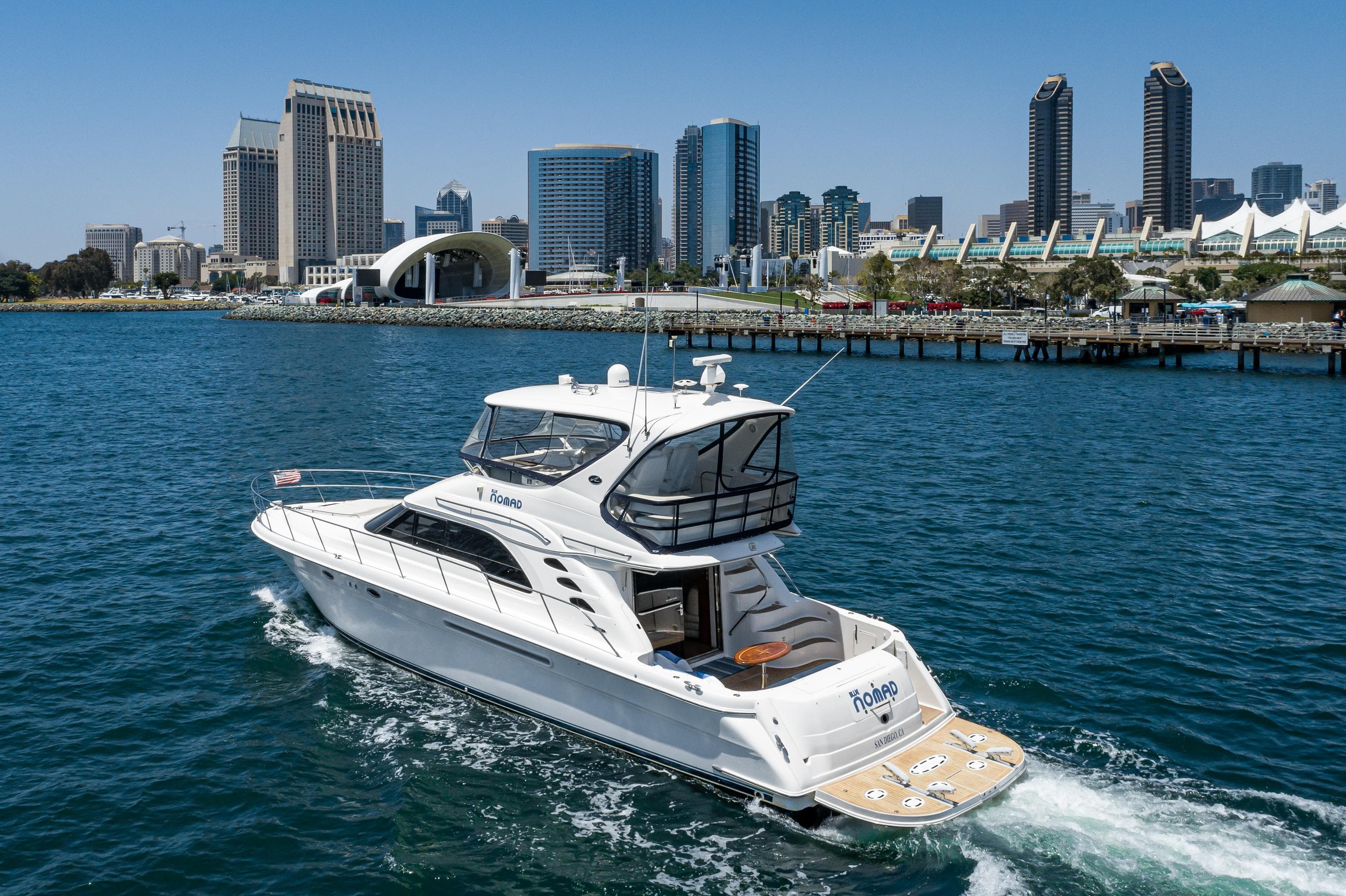 2001 Sea Ray 560 Sedan Bridge yacht cruising near city skyline.