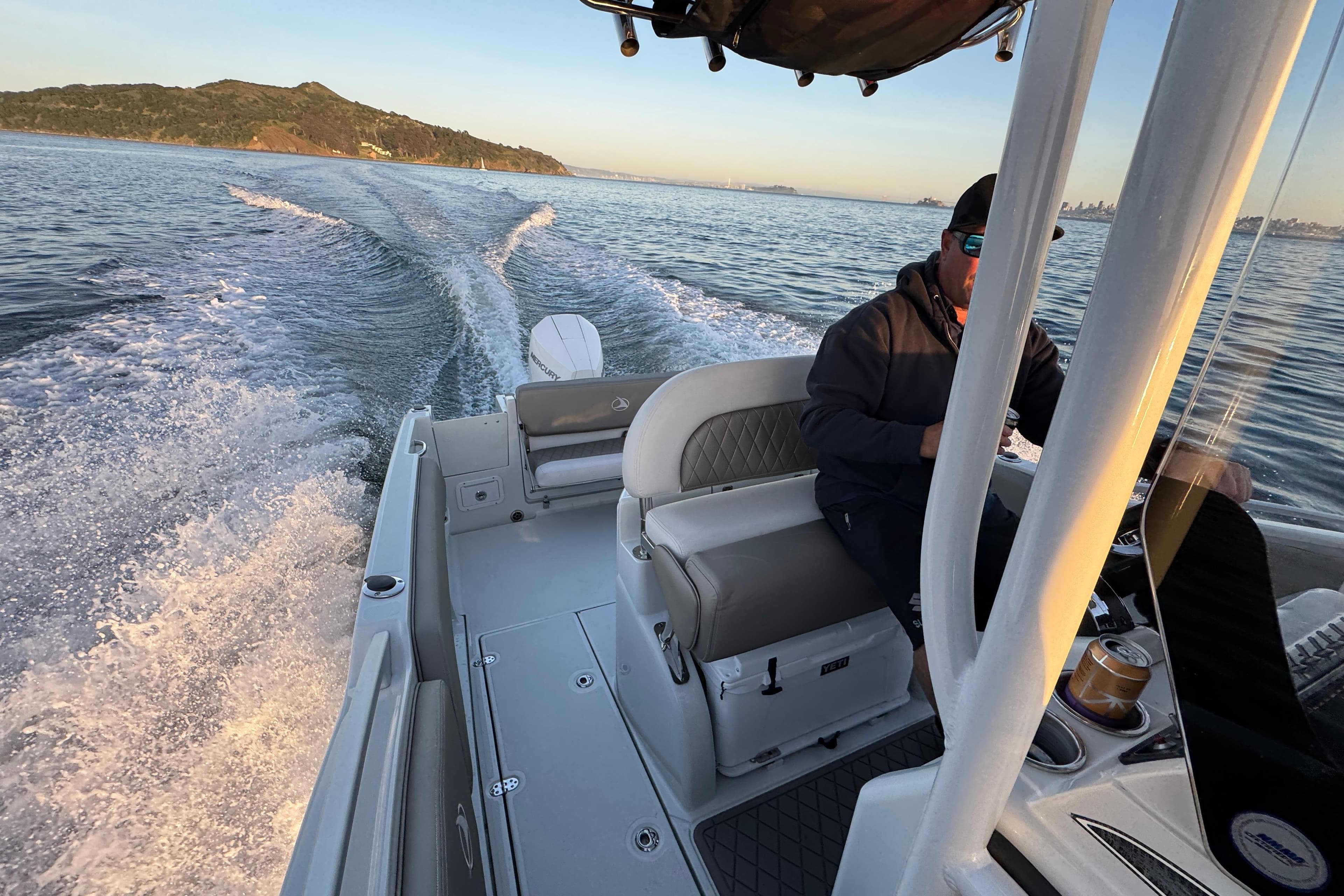 2023 Finseeker 230 CC cruising on open water with scenic coastal backdrop.