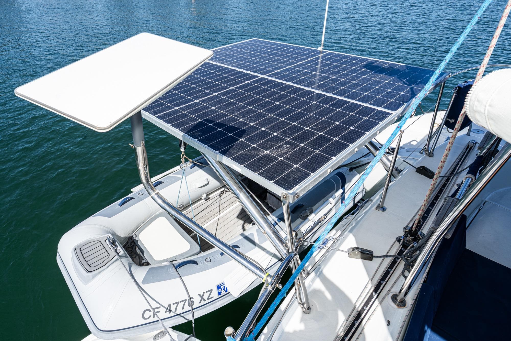 Lagoon 380 catamaran with solar panels and dinghy, 2004 model, on water.
