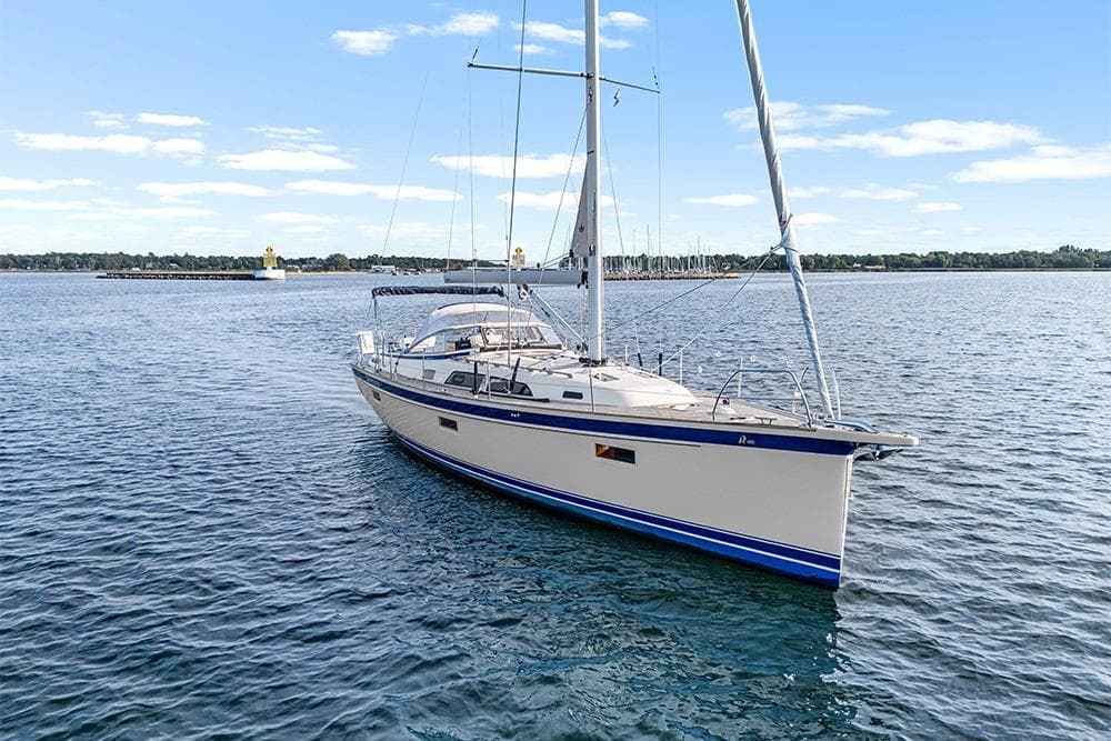 2022 Hallberg-Rassy 400 sailboat on calm water under a clear blue sky.