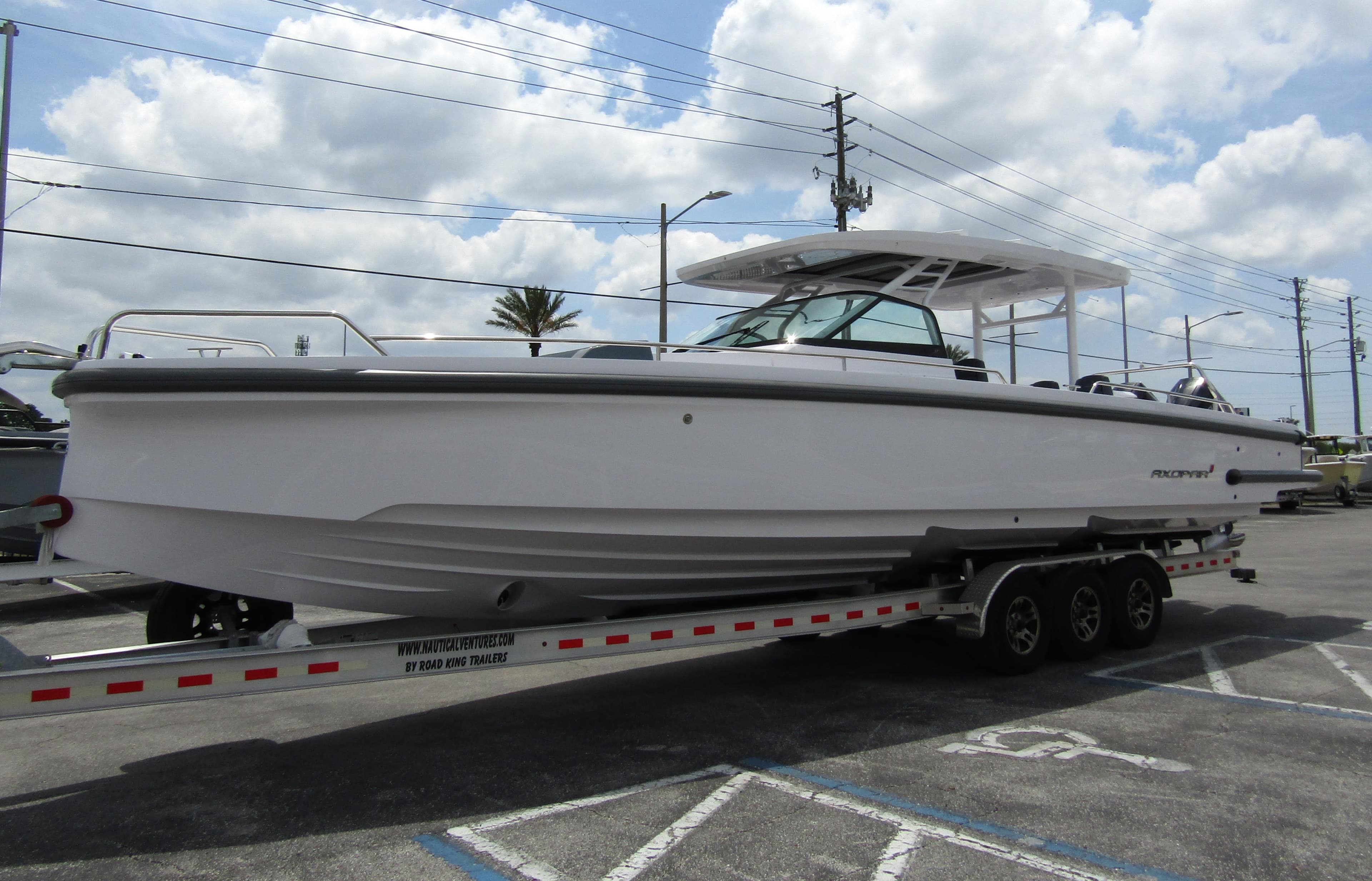2024 Axopar 37 Sun Top boat on trailer under cloudy sky.