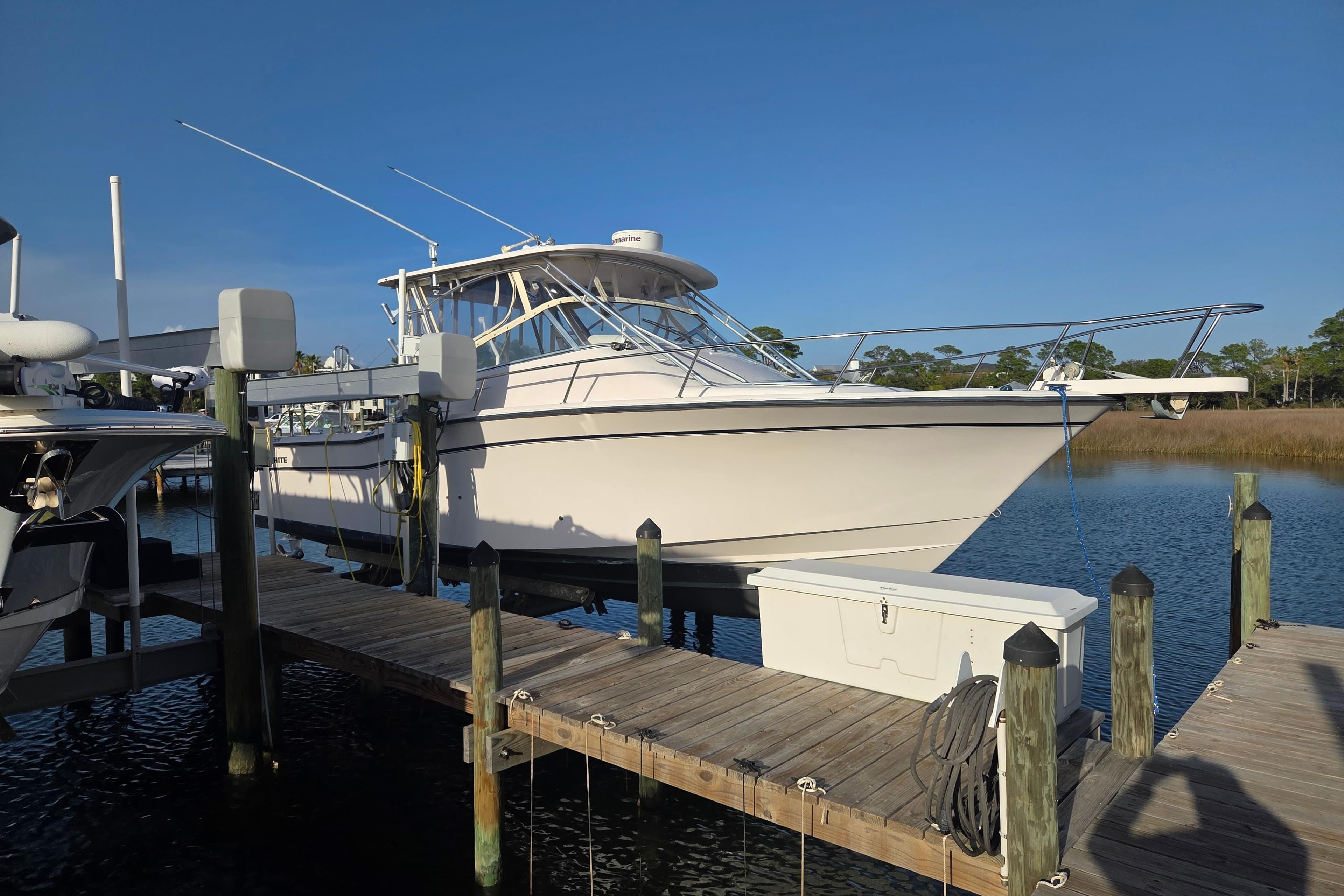 2004 Grady-White Express 330 boat docked at marina under clear blue sky.