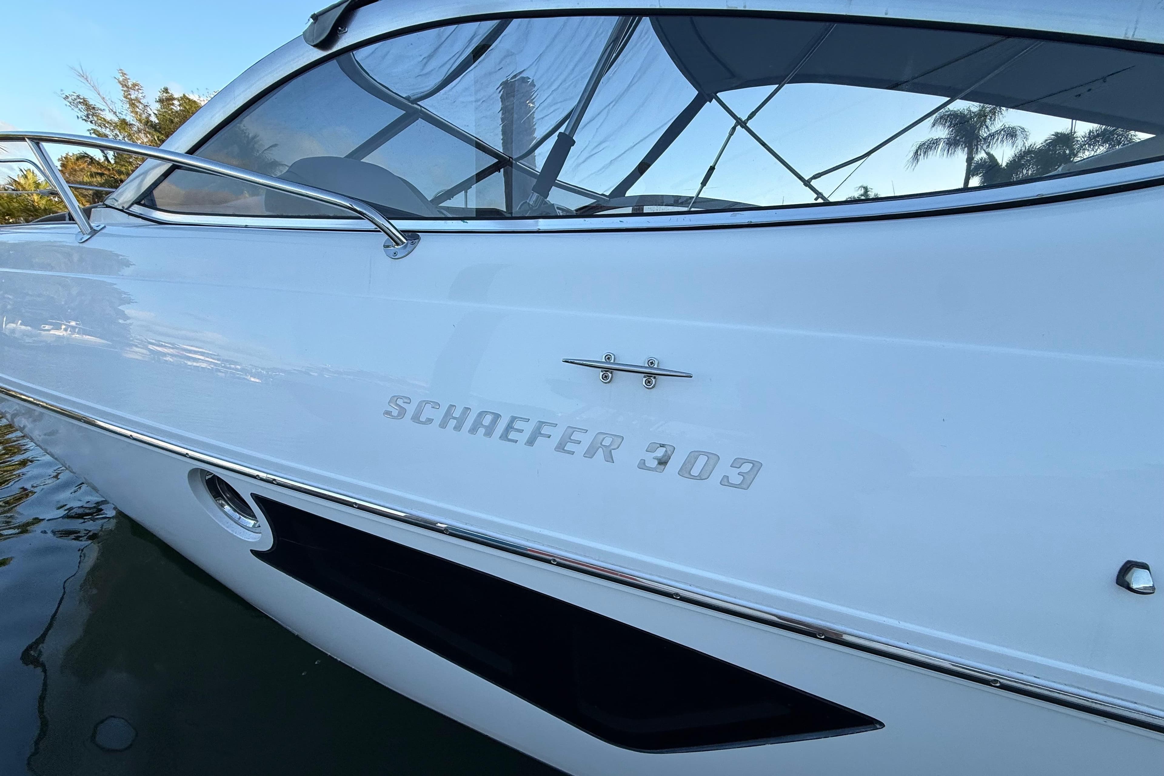 2021 Schaefer 303 boat side view with sleek white design and logo.