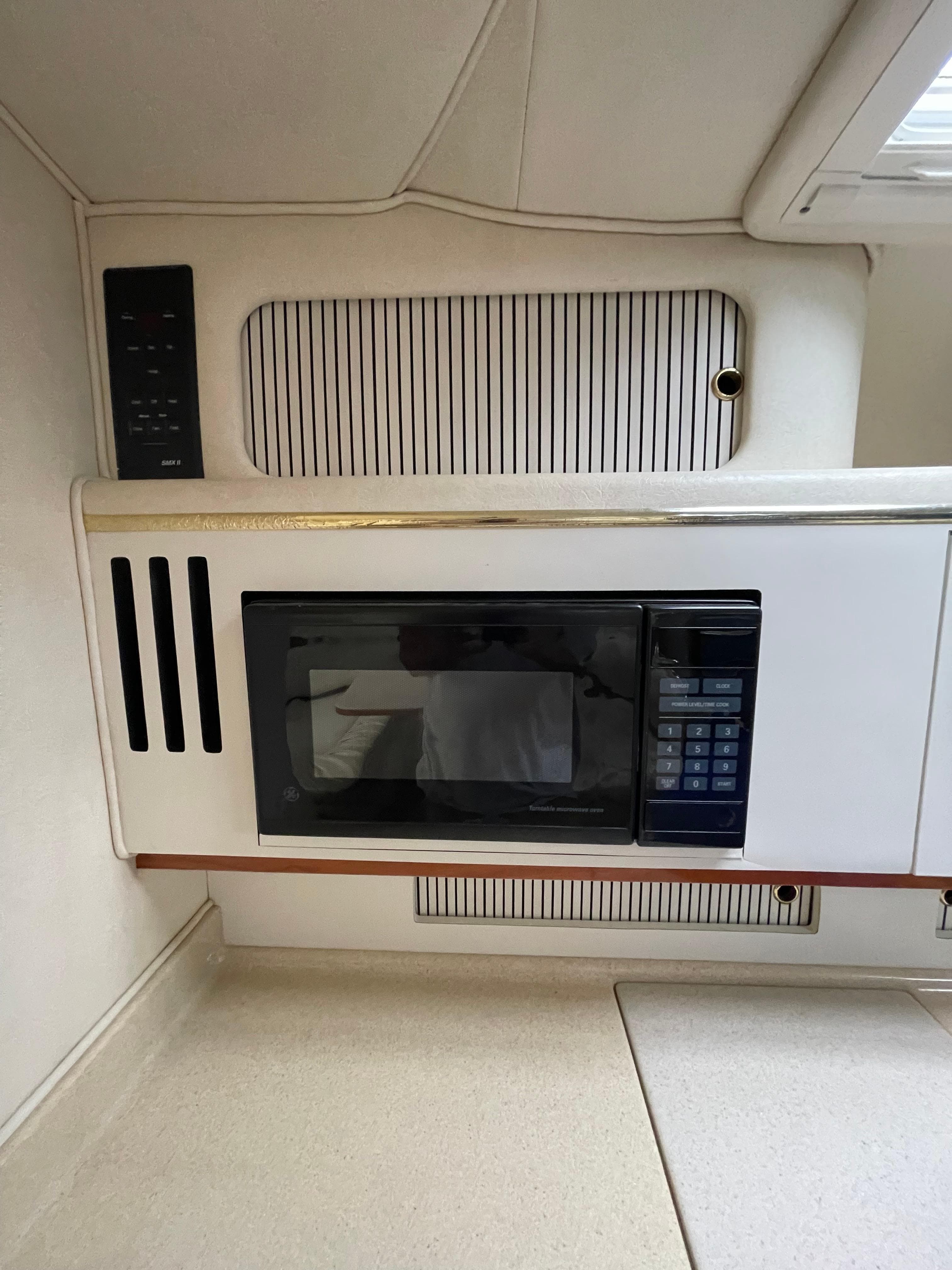 2001 Sea Ray 310 Sundancer interior with built-in microwave and cabinetry.