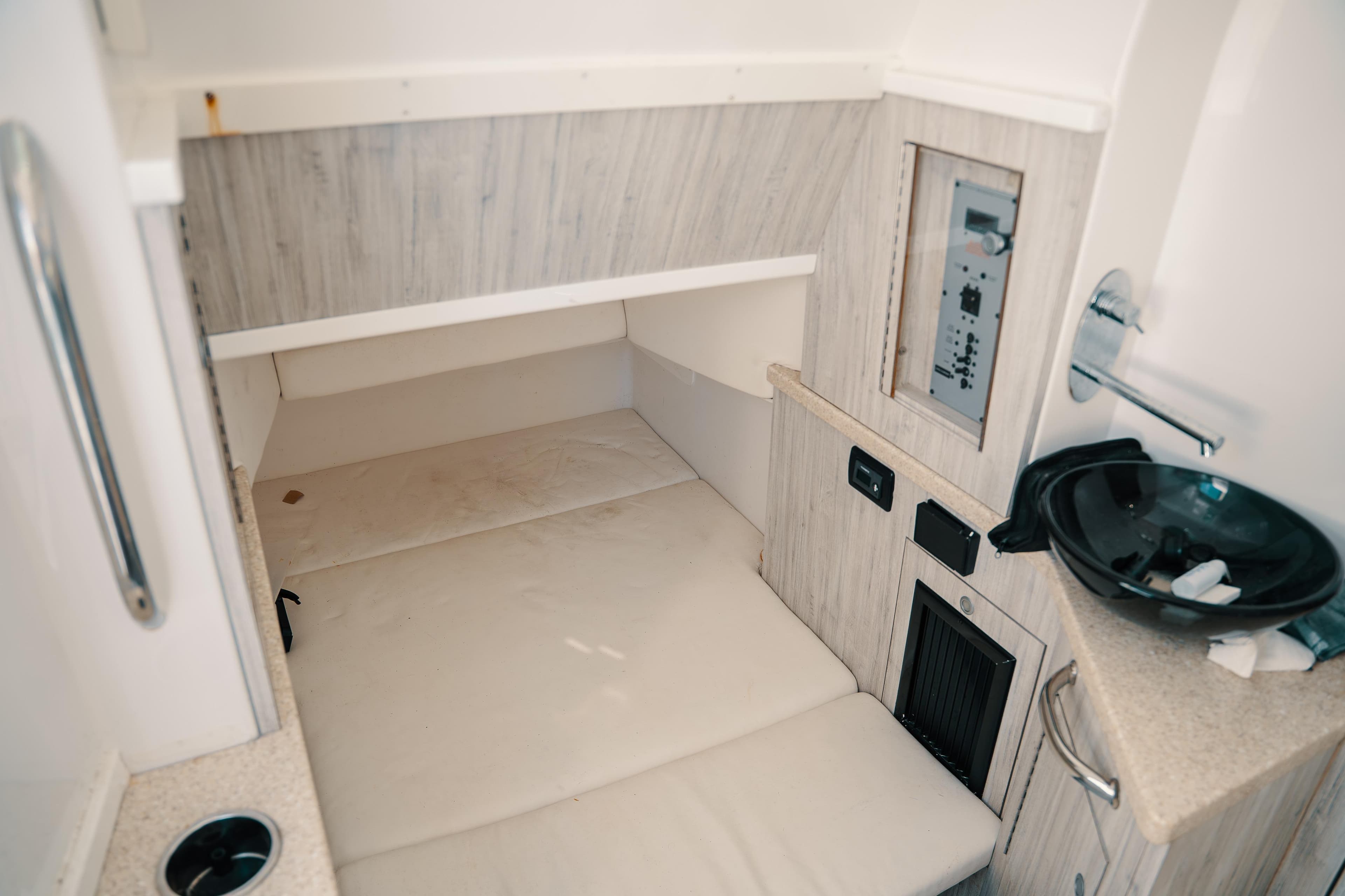 Interior cabin of 2019 HCB 42 Siesta boat with bed and control panel.