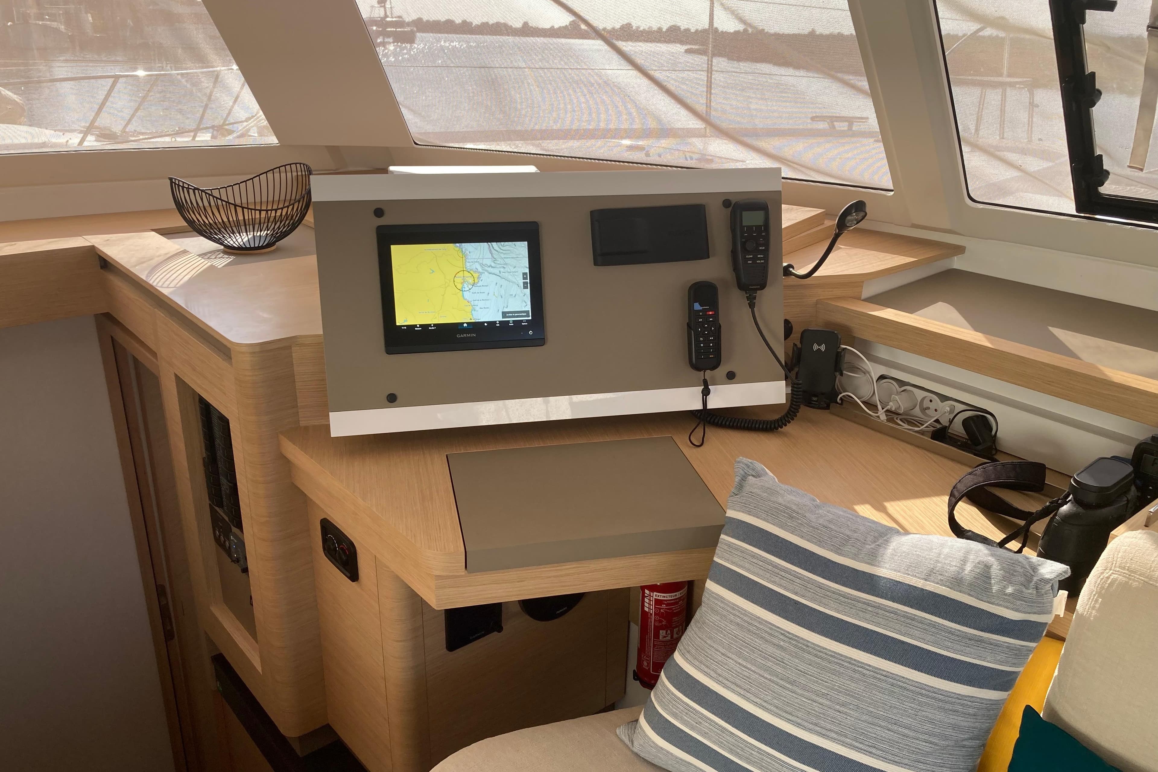 2024 Fountaine Pajot Catamaran Astrea 42 interior helm with navigation equipment and cozy seating.