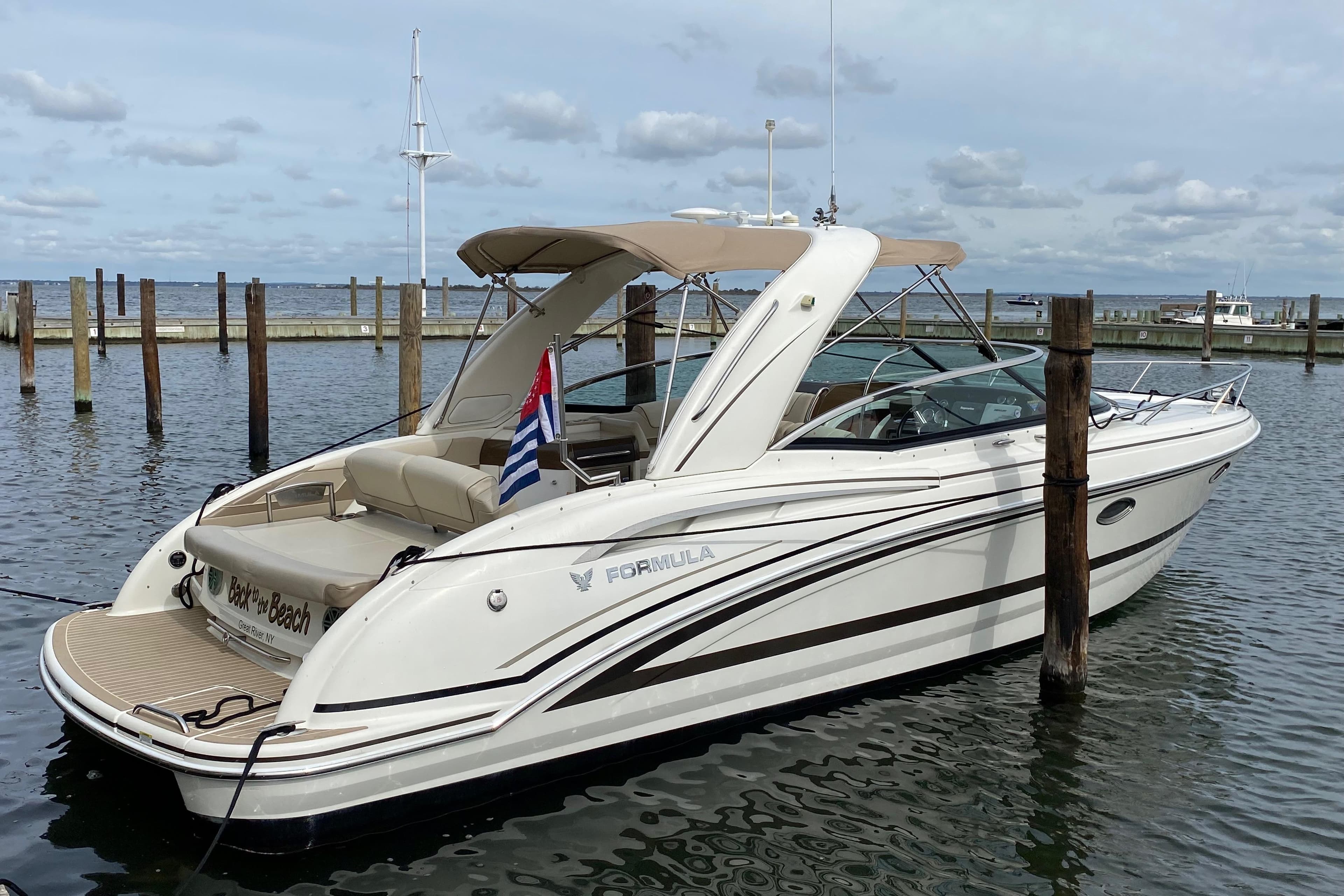 2015 Formula 310 Sun Sport boat docked in a marina, featuring sleek design and luxury amenities.