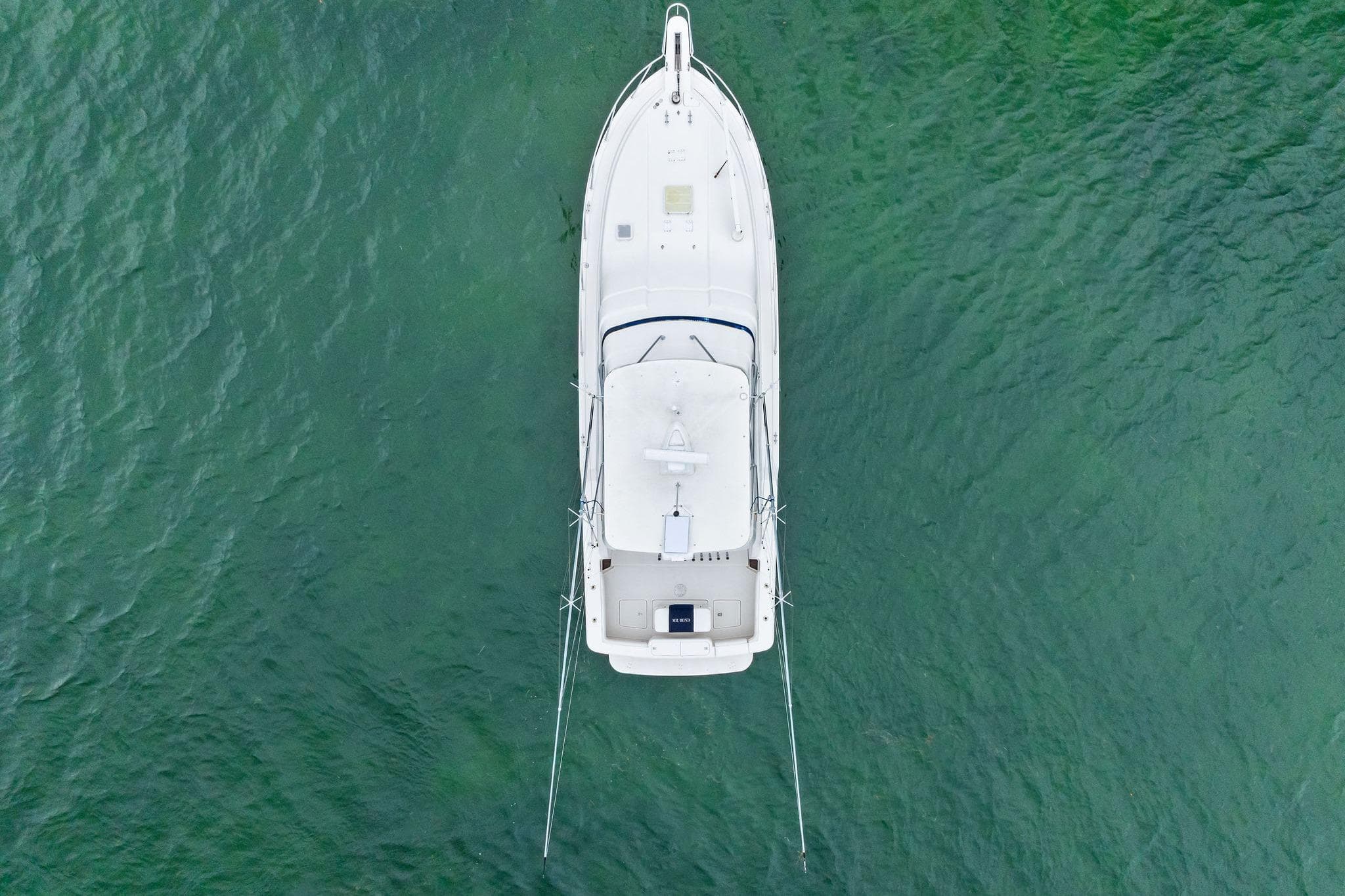 Aerial view of 2006 Bertram 39 Convertible yacht on green water.