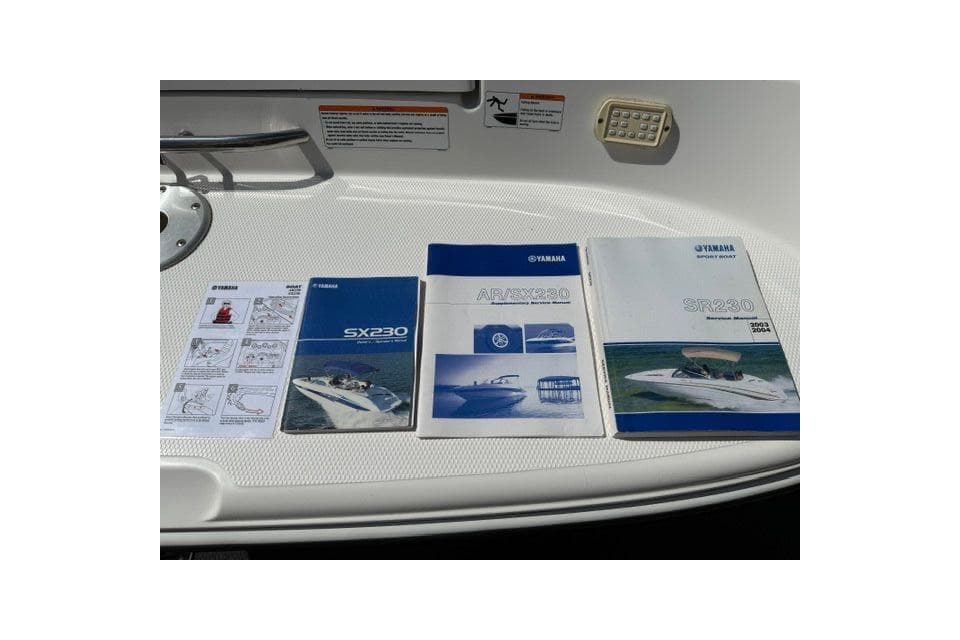 2004 Yamaha Boats SX230 manuals displayed on a boat surface.