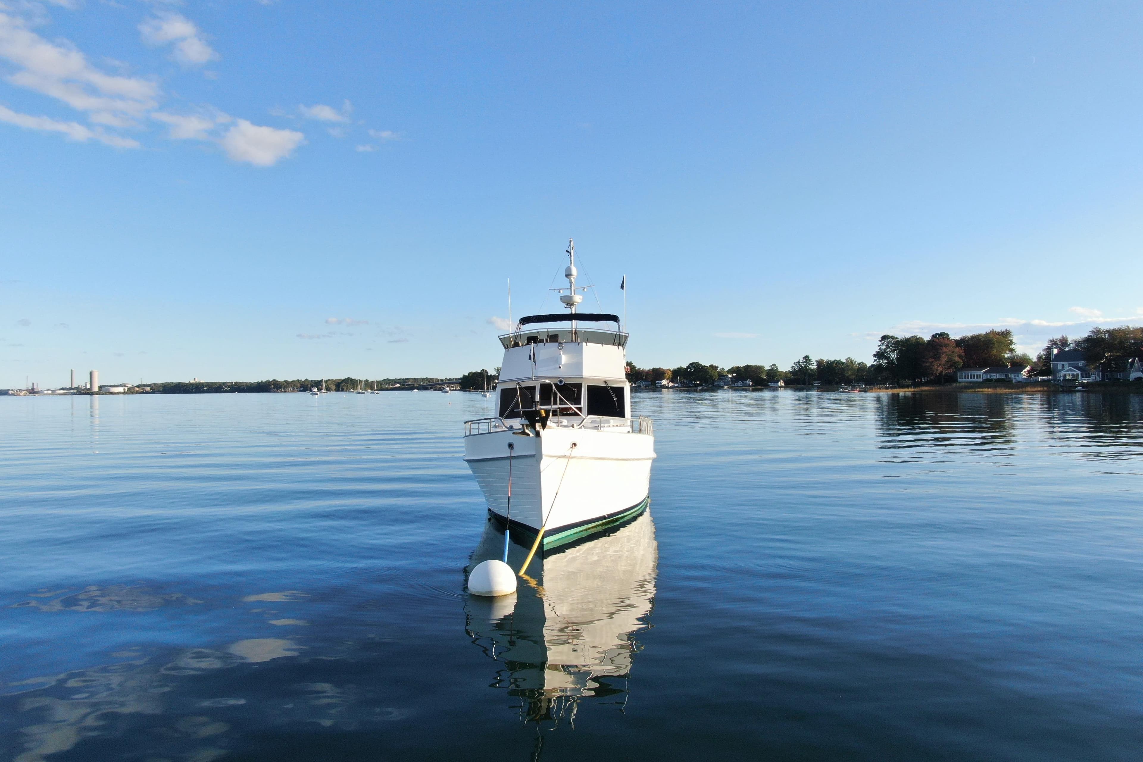 1989 Grand Banks 46 Classic yacht moored on calm water under clear blue sky.