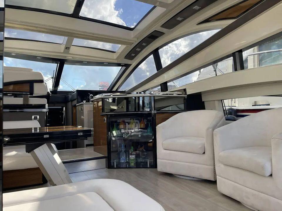 Luxurious interior of a 2009 Marquis 500 Sport Coupe yacht with modern seating and panoramic windows.