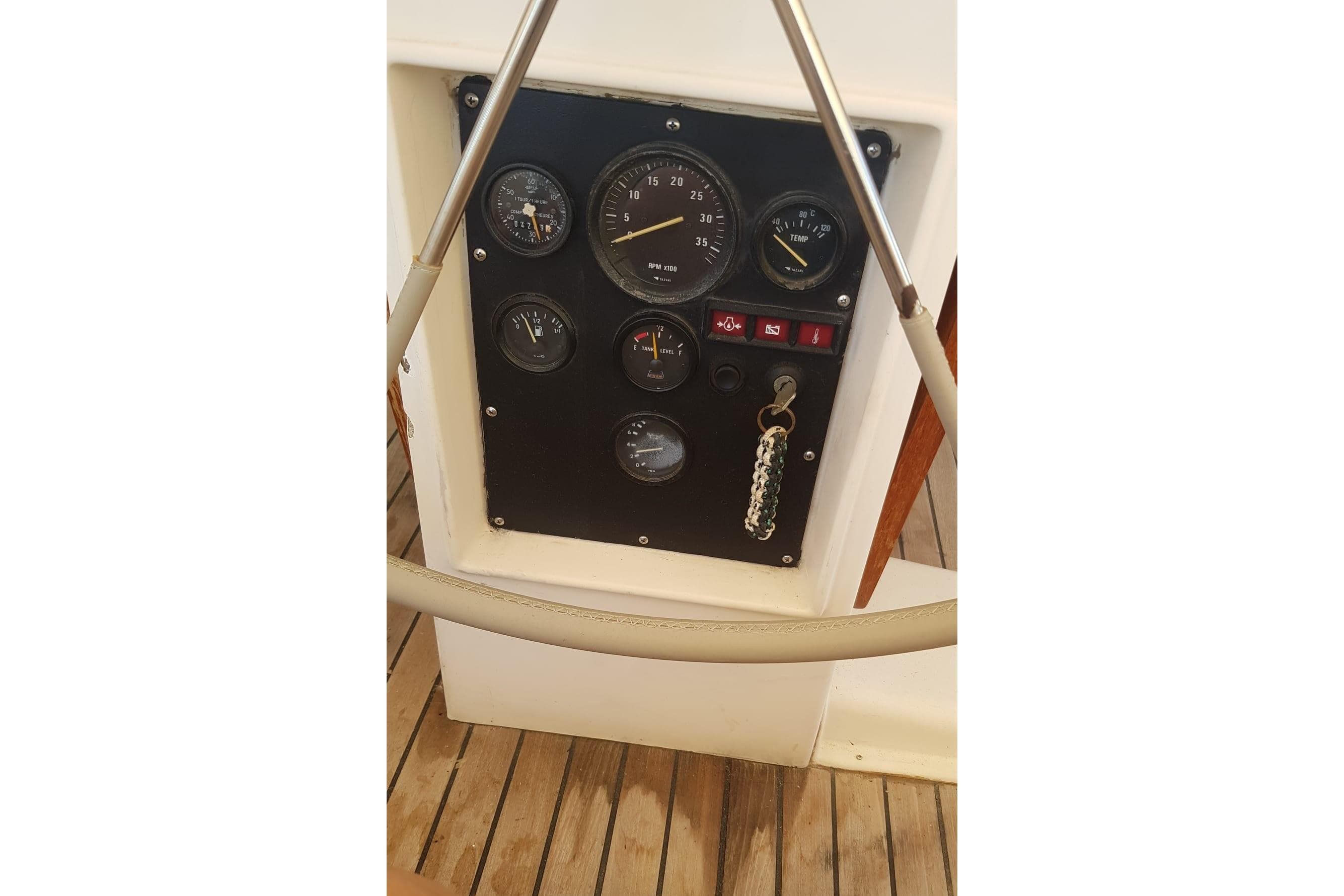 Control panel of a 1989 North Wind 56 yacht with gauges and keychain.