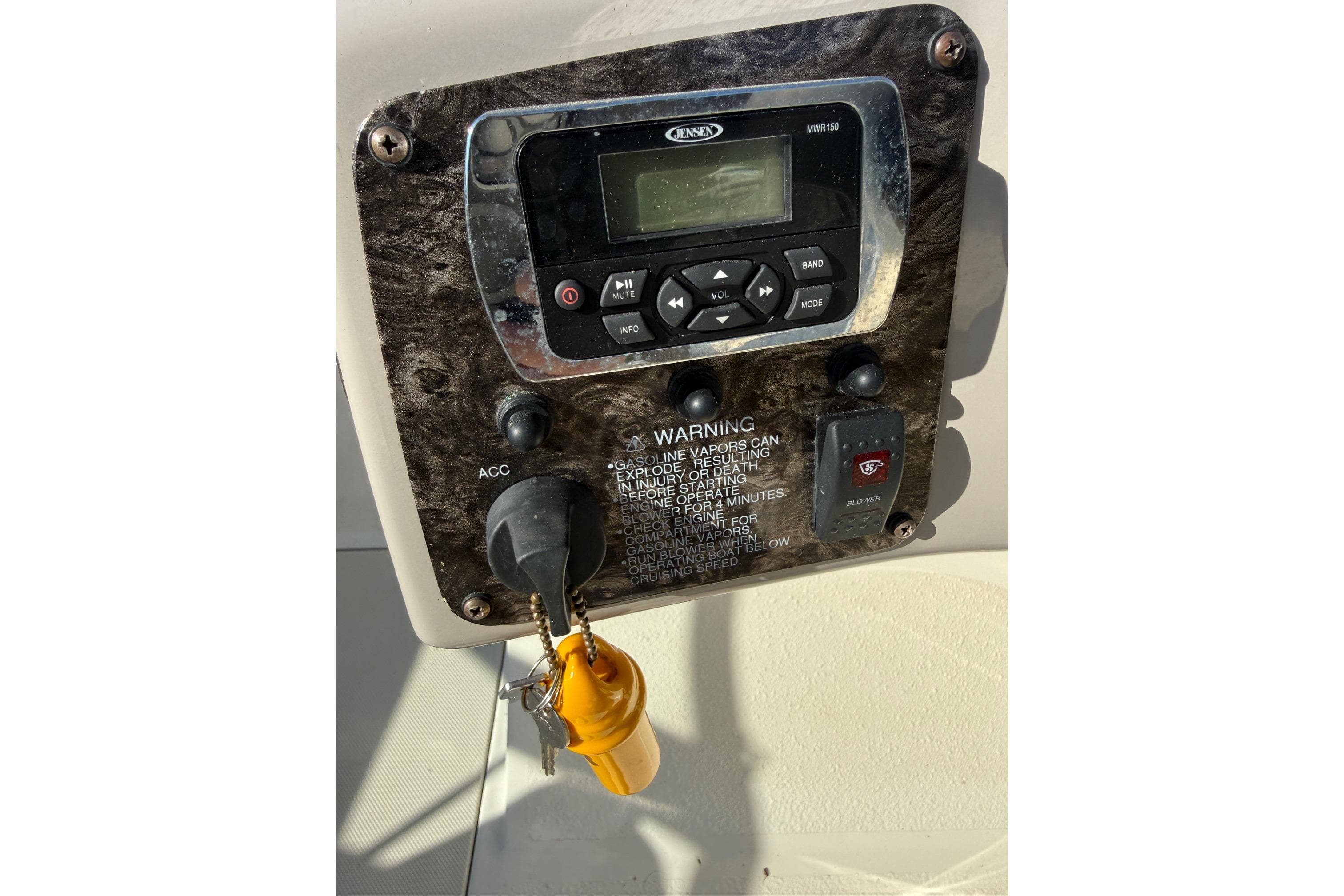 Control panel of a 2014 Stingray 208 LR boat with ignition keys and warning label.