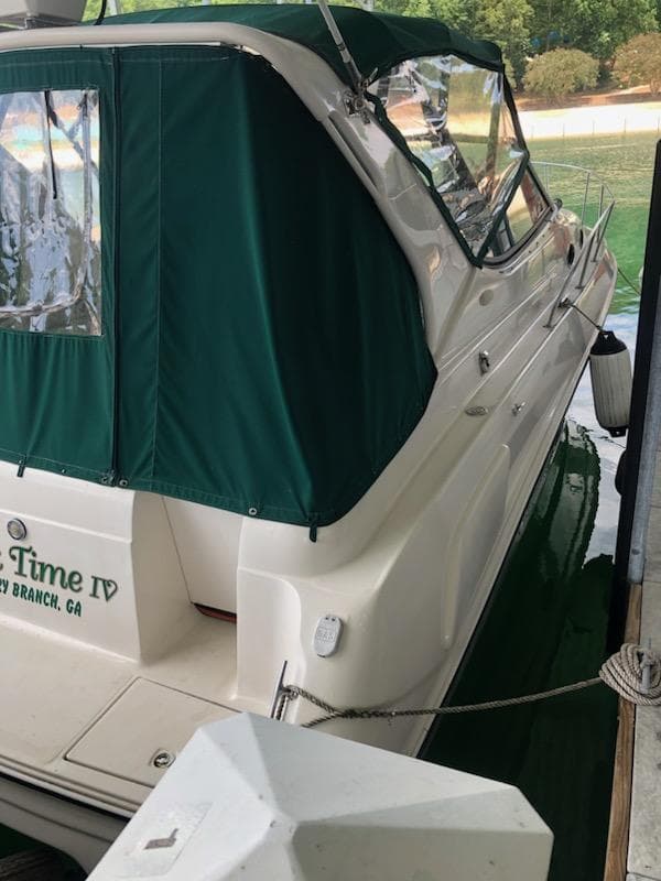 1997 Regal 292 Commodore boat with green canopy docked.