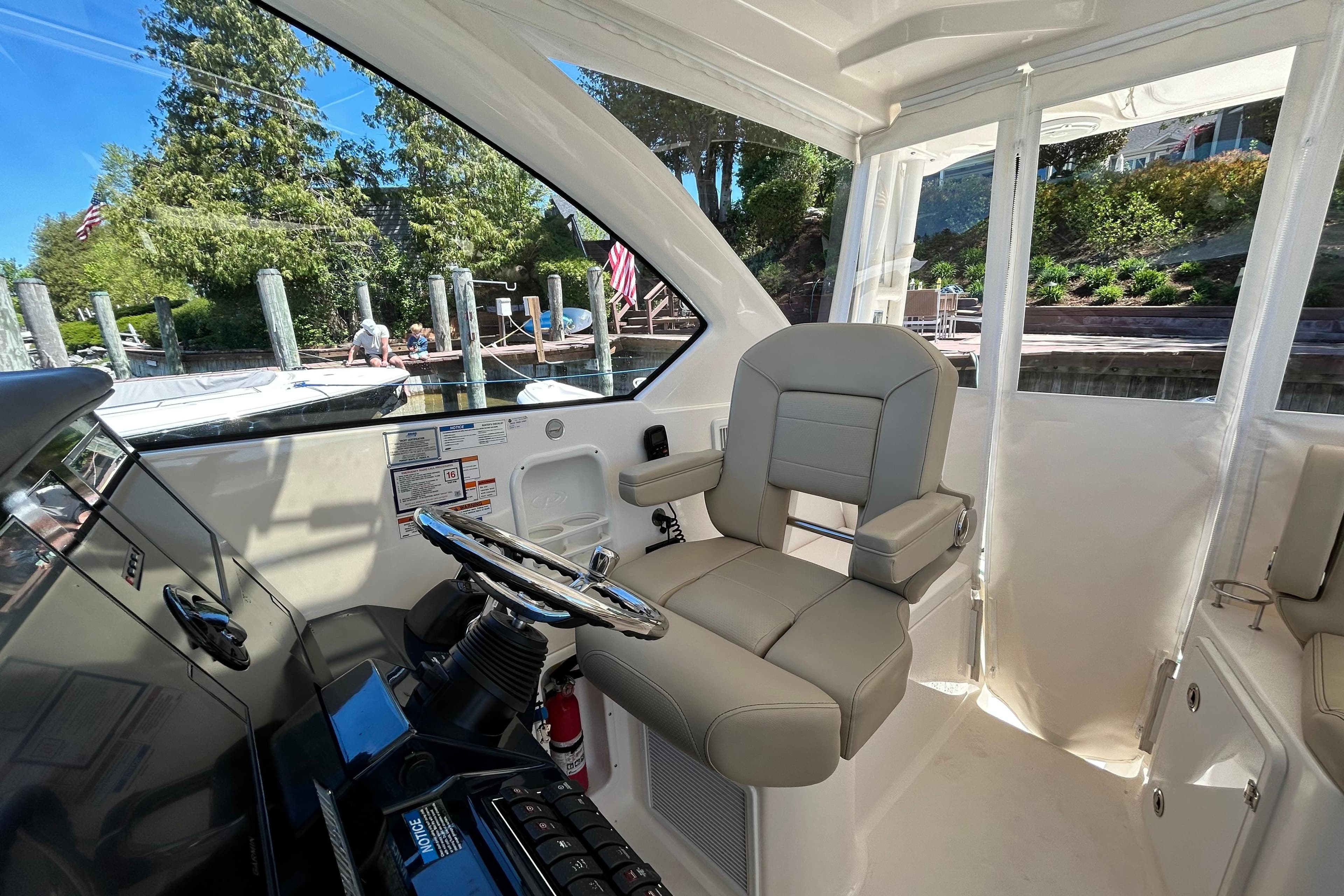 2018 Pursuit OS 355 Offshore helm with comfortable seating and modern controls, dockside view.