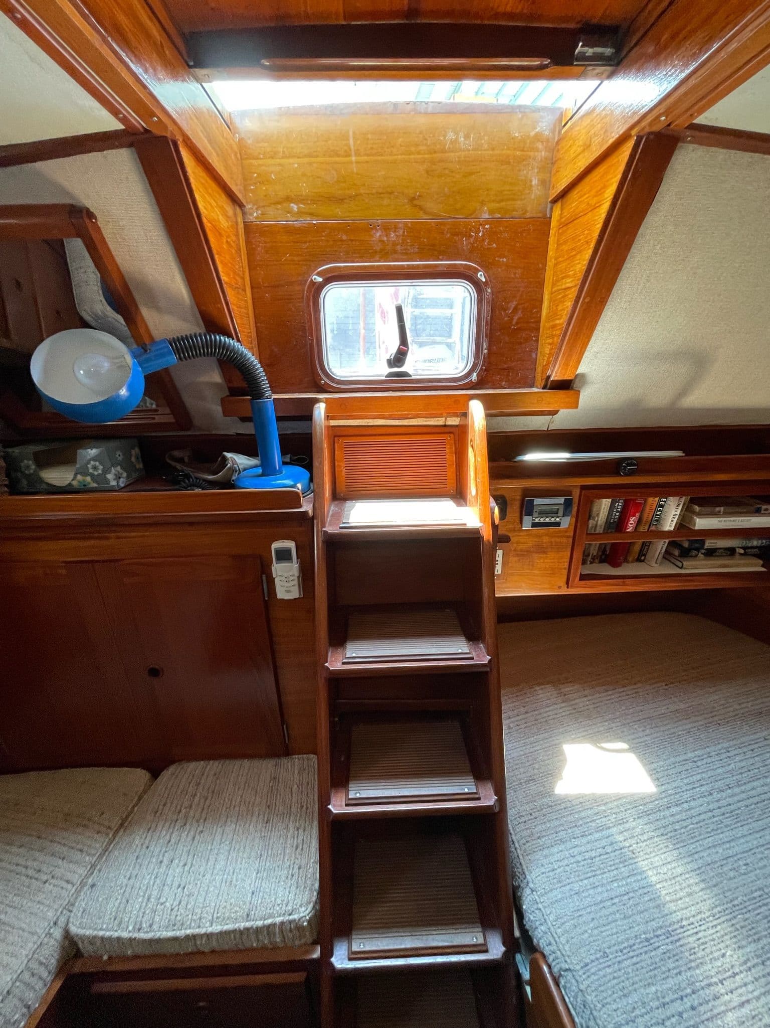 Interior of 1977 Alden Boothbay Explorer with wooden stairs and bookshelf.