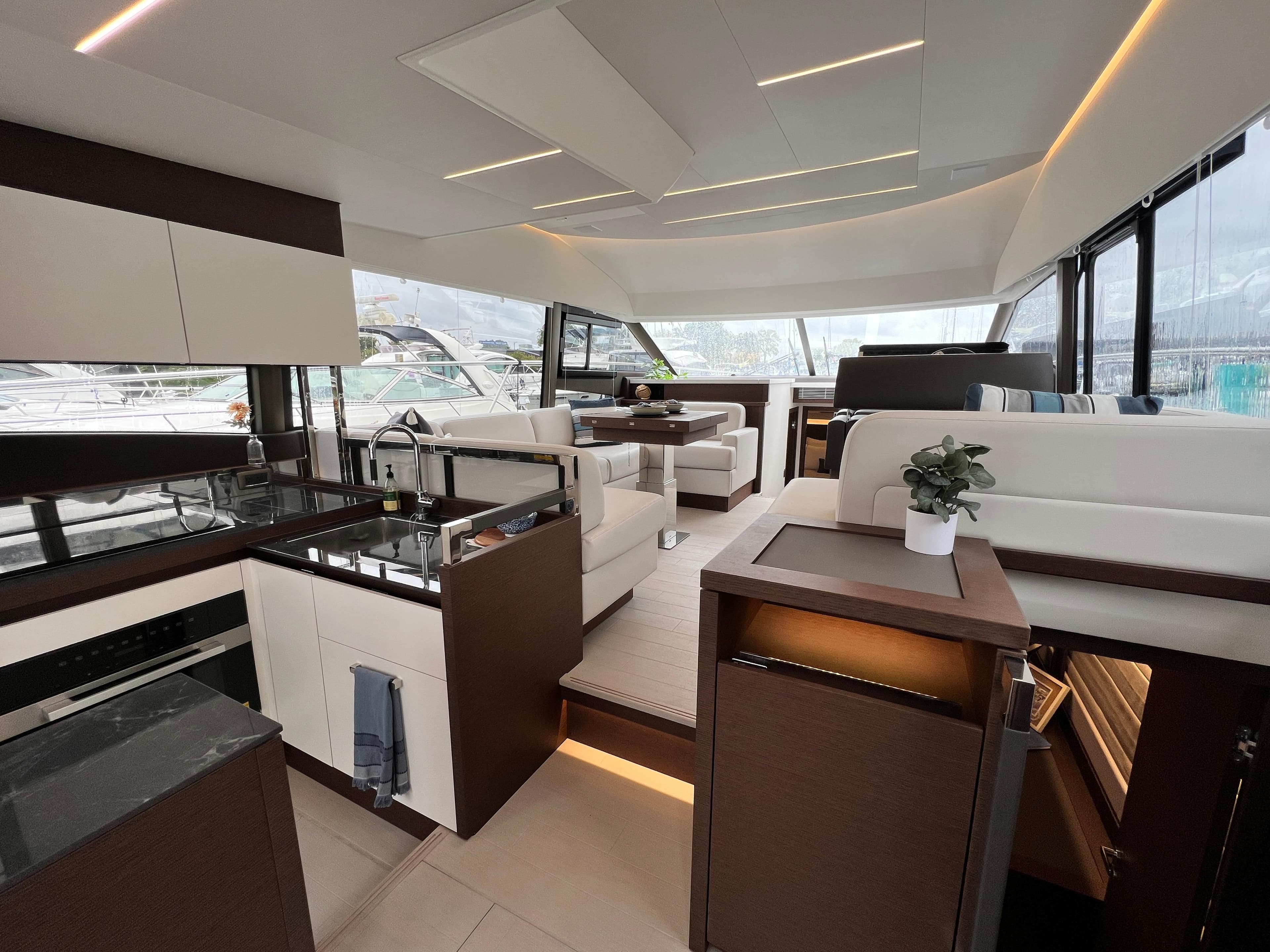 Luxurious interior of 2024 Prestige 520 Flybridge yacht with modern kitchen and seating area.