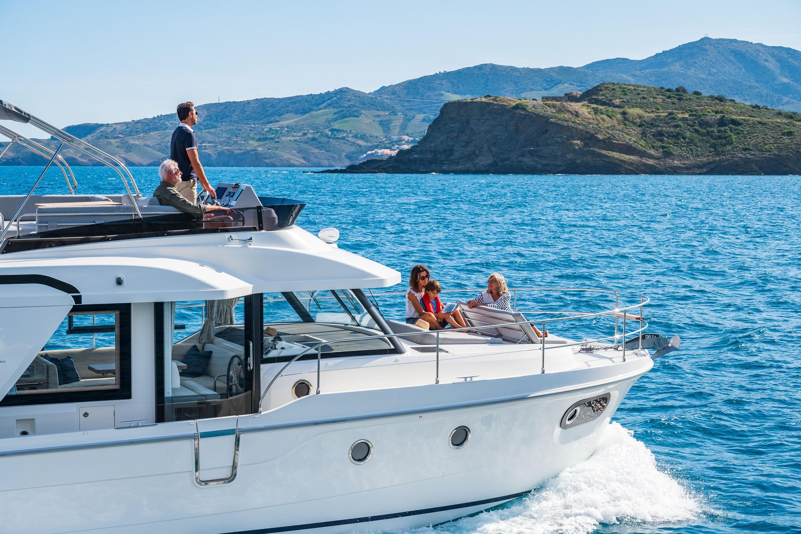 2026 Beneteau Swift Trawler 41 Fly cruising with passengers, scenic coastal backdrop.