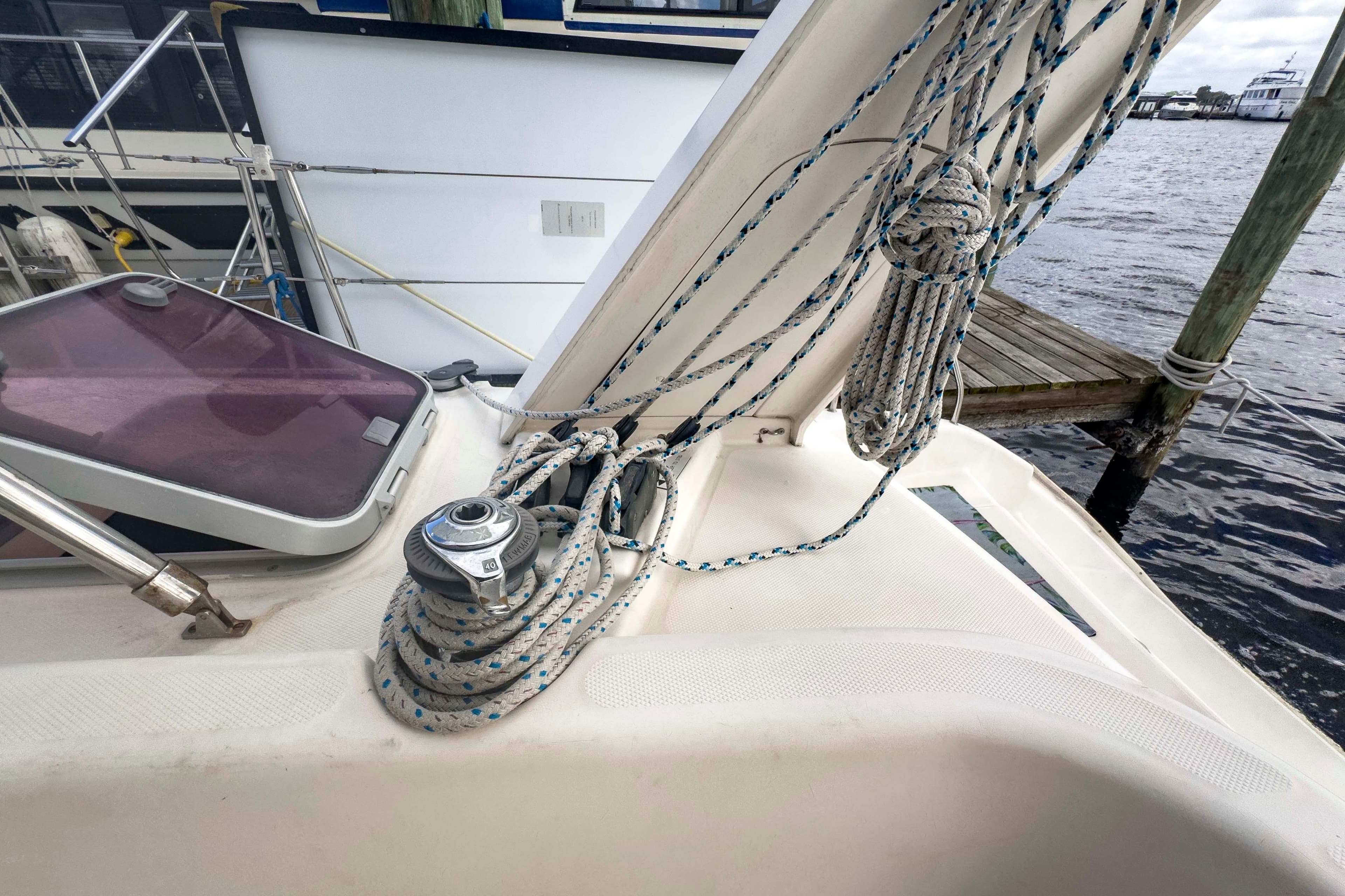 Leopard 42 sailboat deck with ropes and winch, docked by the water.