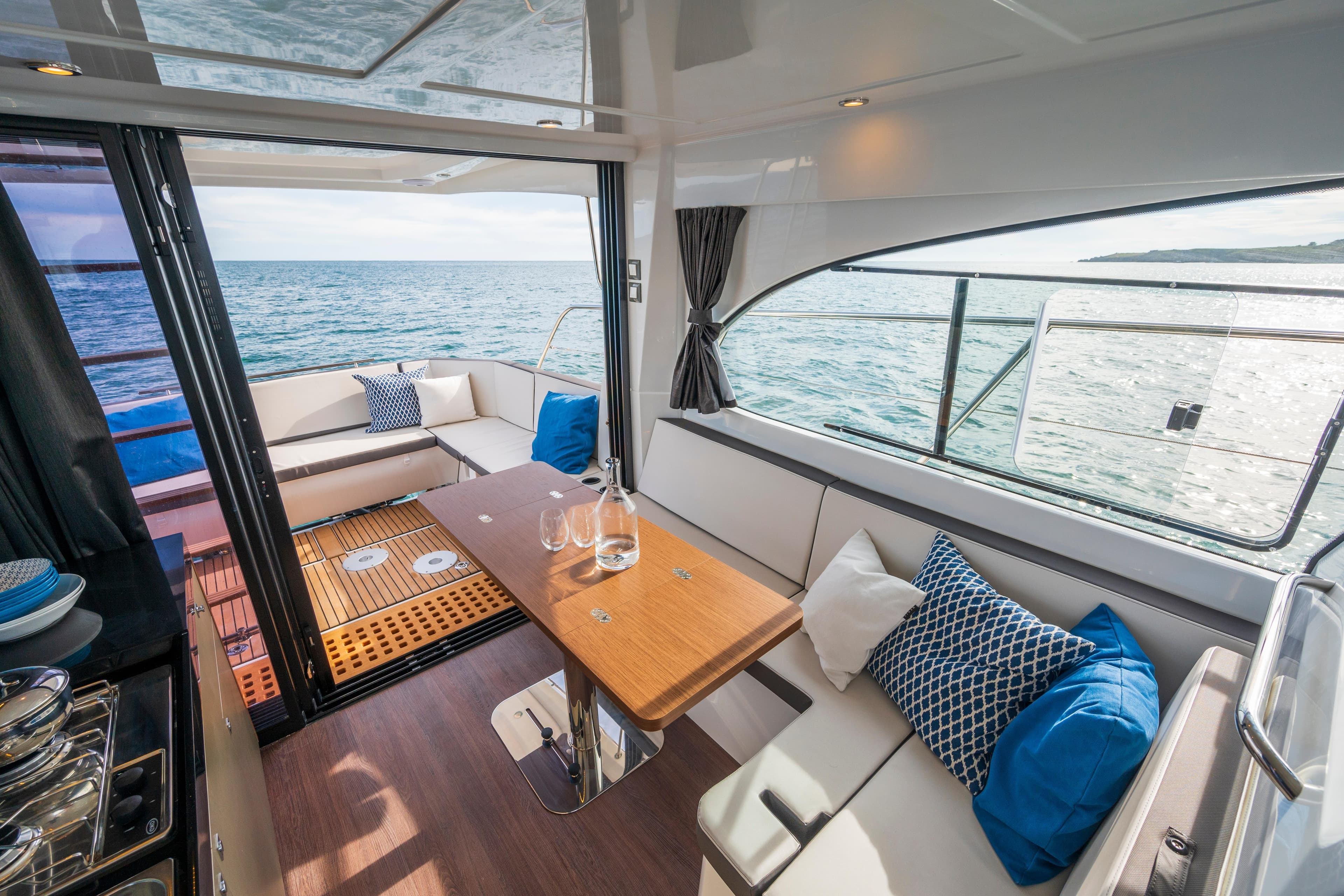 Interior of 2026 Beneteau Antares 11 Coupe with ocean view and cozy seating area.