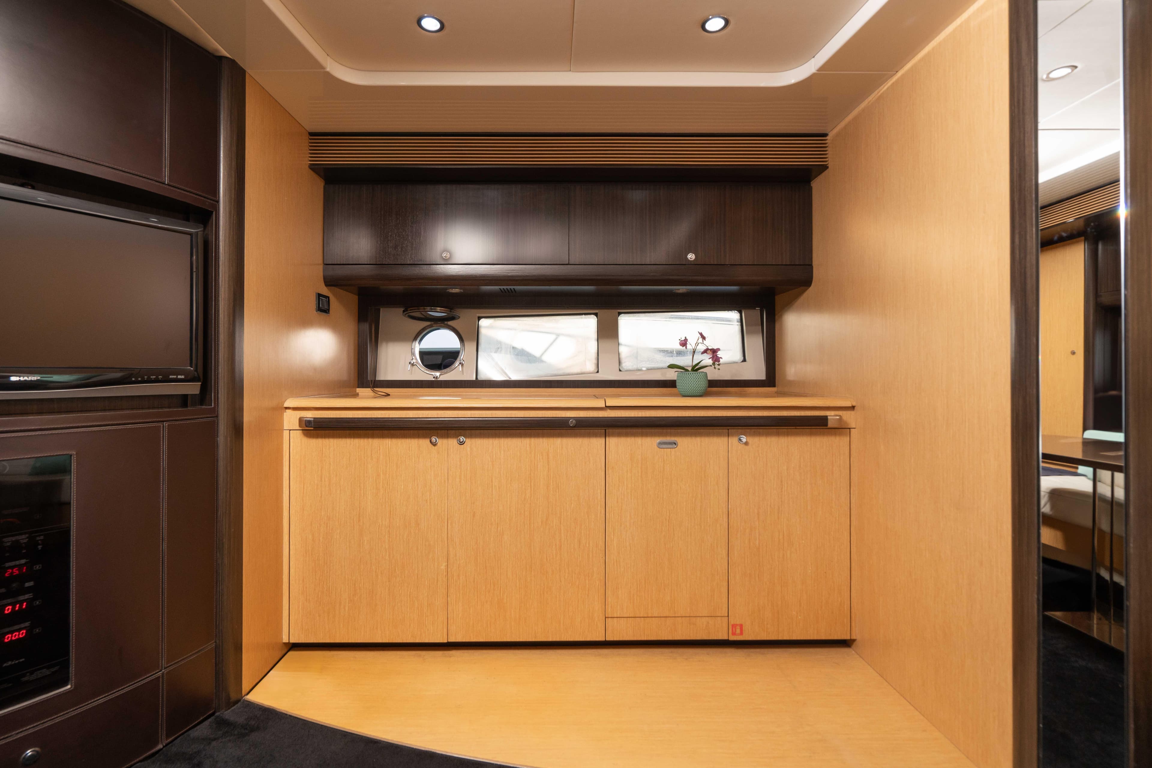 Interior of 2009 Riva 63 Vertigo yacht with modern wood cabinetry and porthole window.