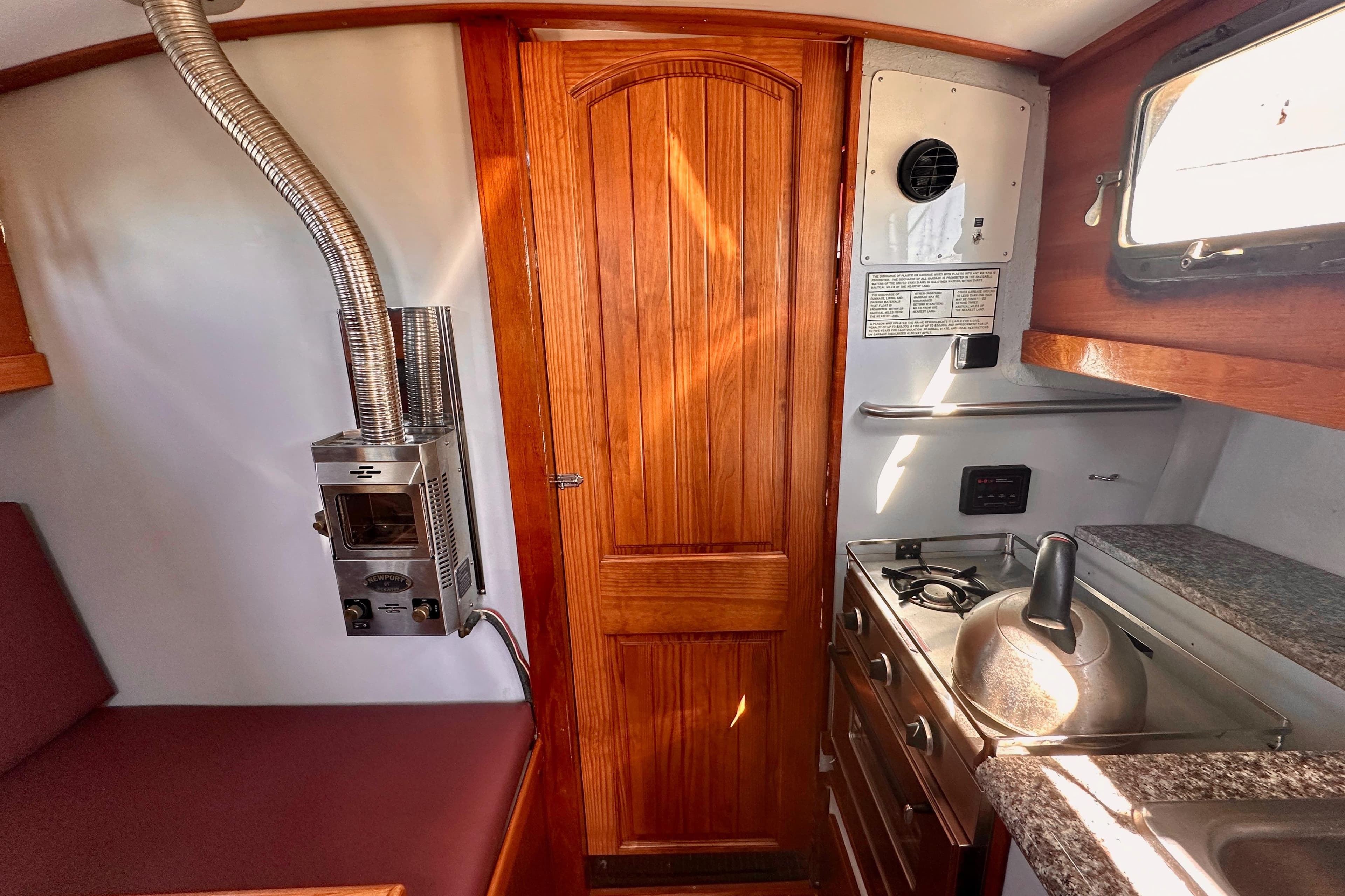 Cozy 1972 Fisher 30 boat interior with wood paneling, stove, and seating area.