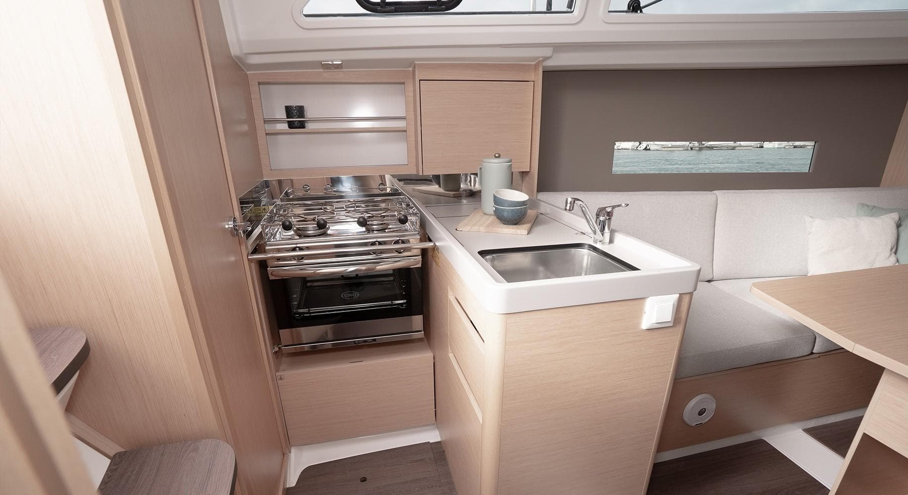 Interior of 2025 Beneteau Oceanis 30.1 yacht, featuring a compact kitchen and seating area.