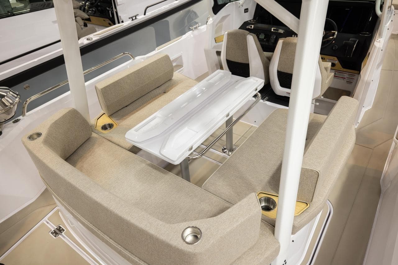 2026 Axopar 29 Sun-Top boat interior with beige seating and a central table.