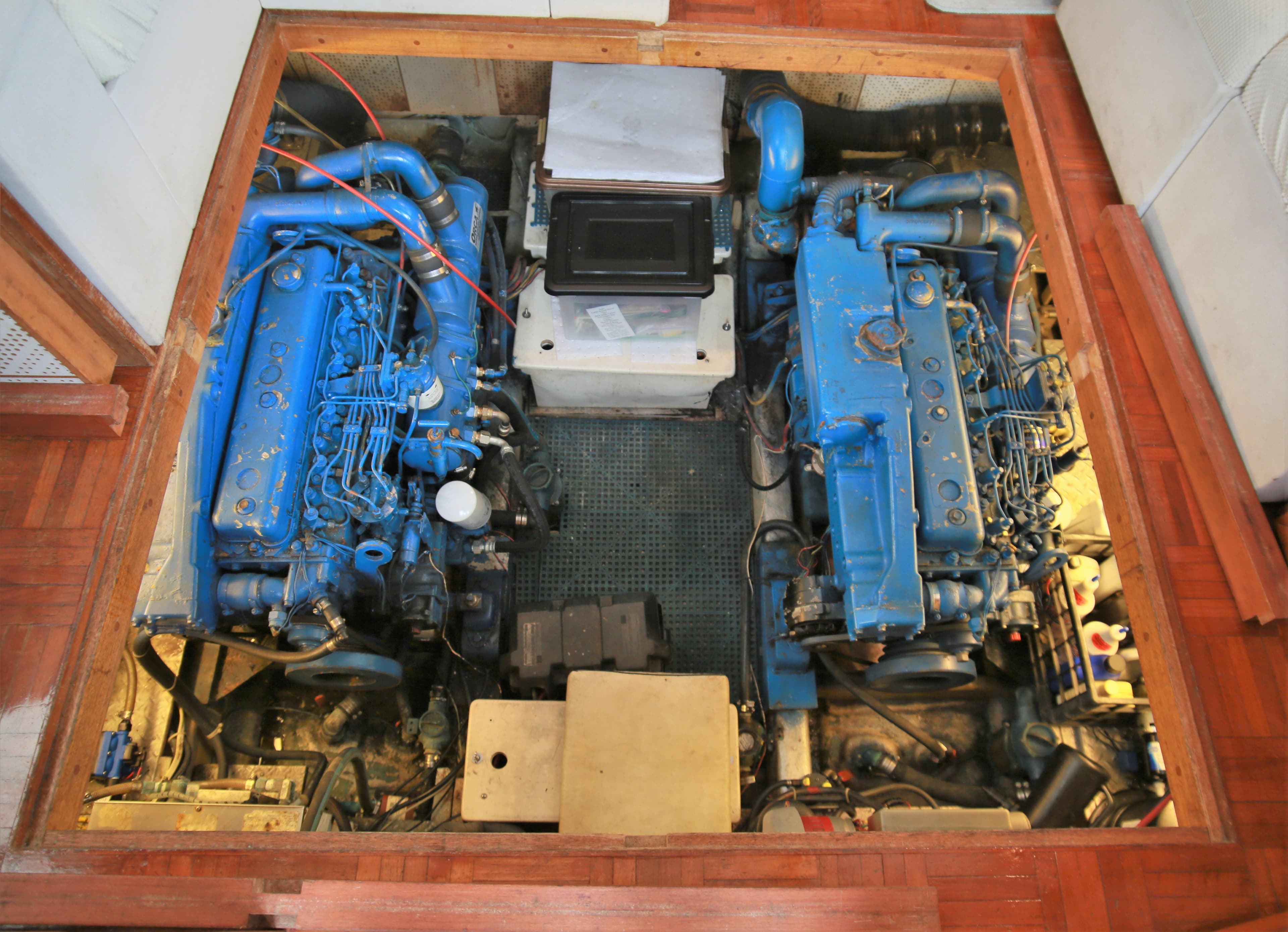 Engine room of a 1987 Jefferson 42 Sundeck Motor Yacht with twin blue engines.