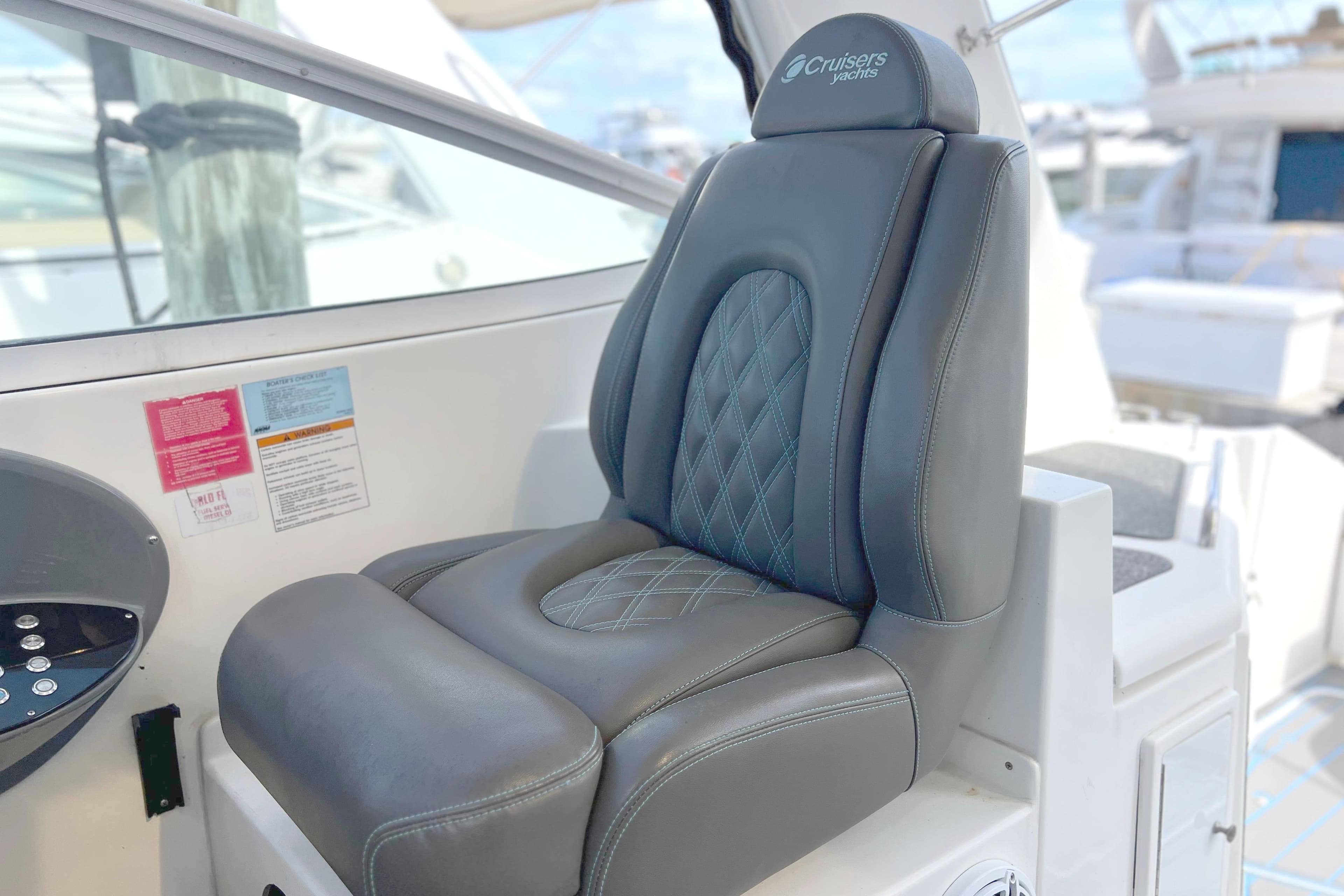 Captain's seat on 2005 Cruisers Yachts 440 Express, featuring luxurious black leather upholstery.